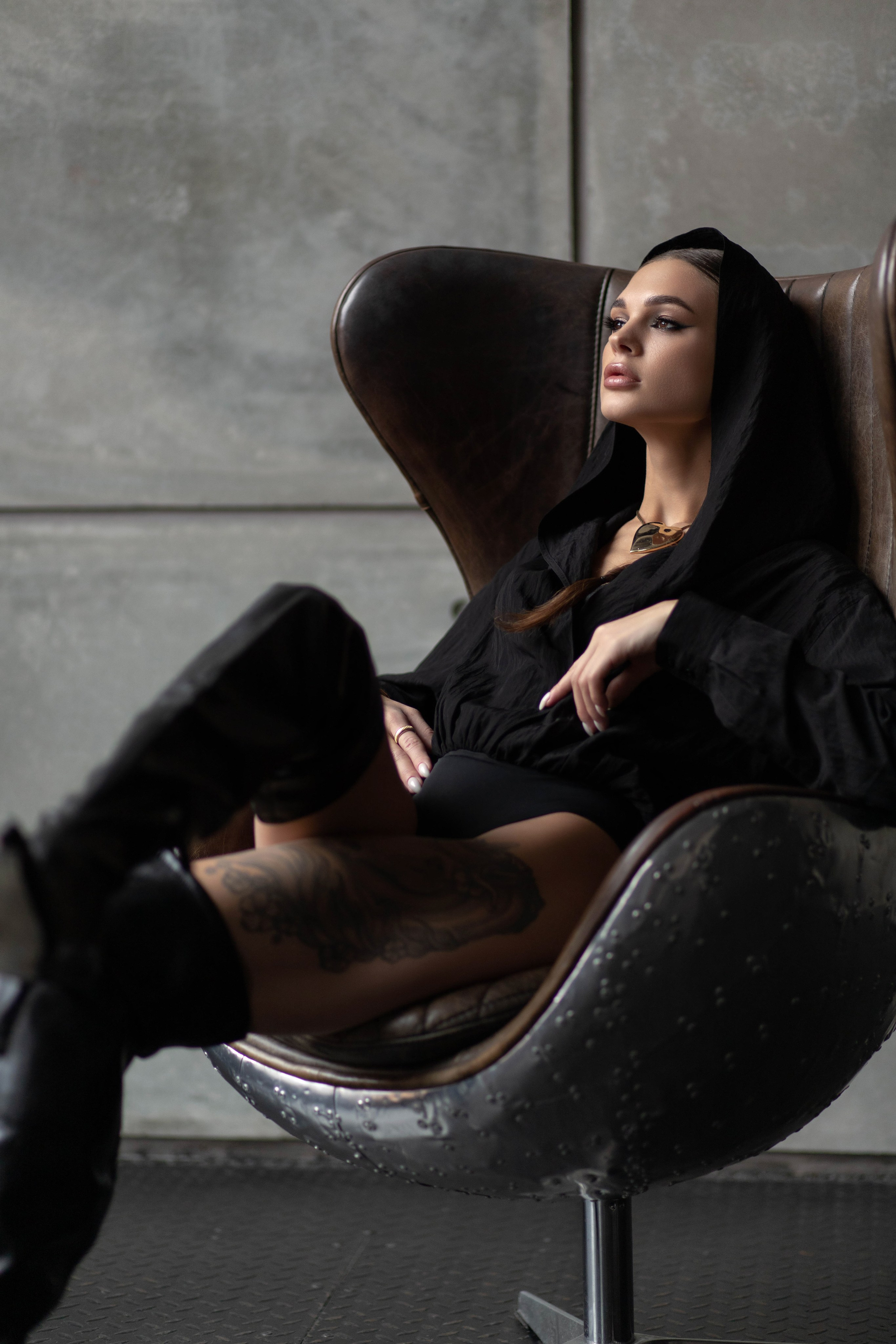 Съемка в студии. Девушка в боди и ботфортах на кресле 