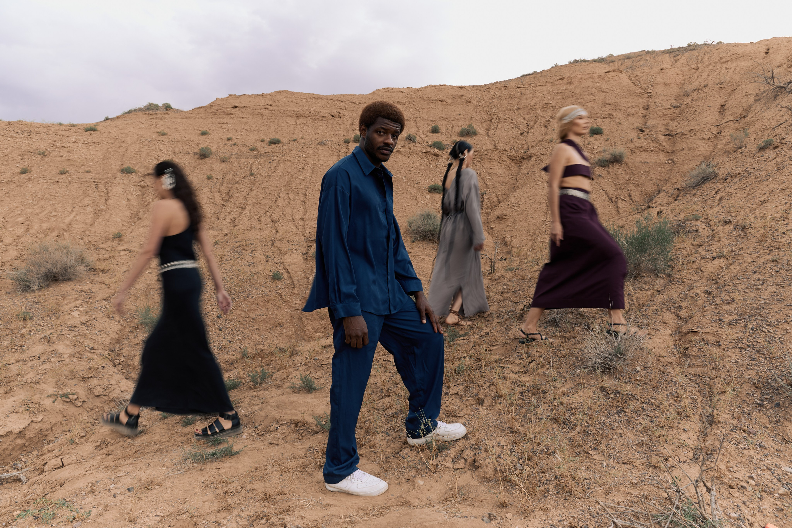 длинная выдержка темнокожий мужчинав  компании трех девушек разных национальностей в пустыни