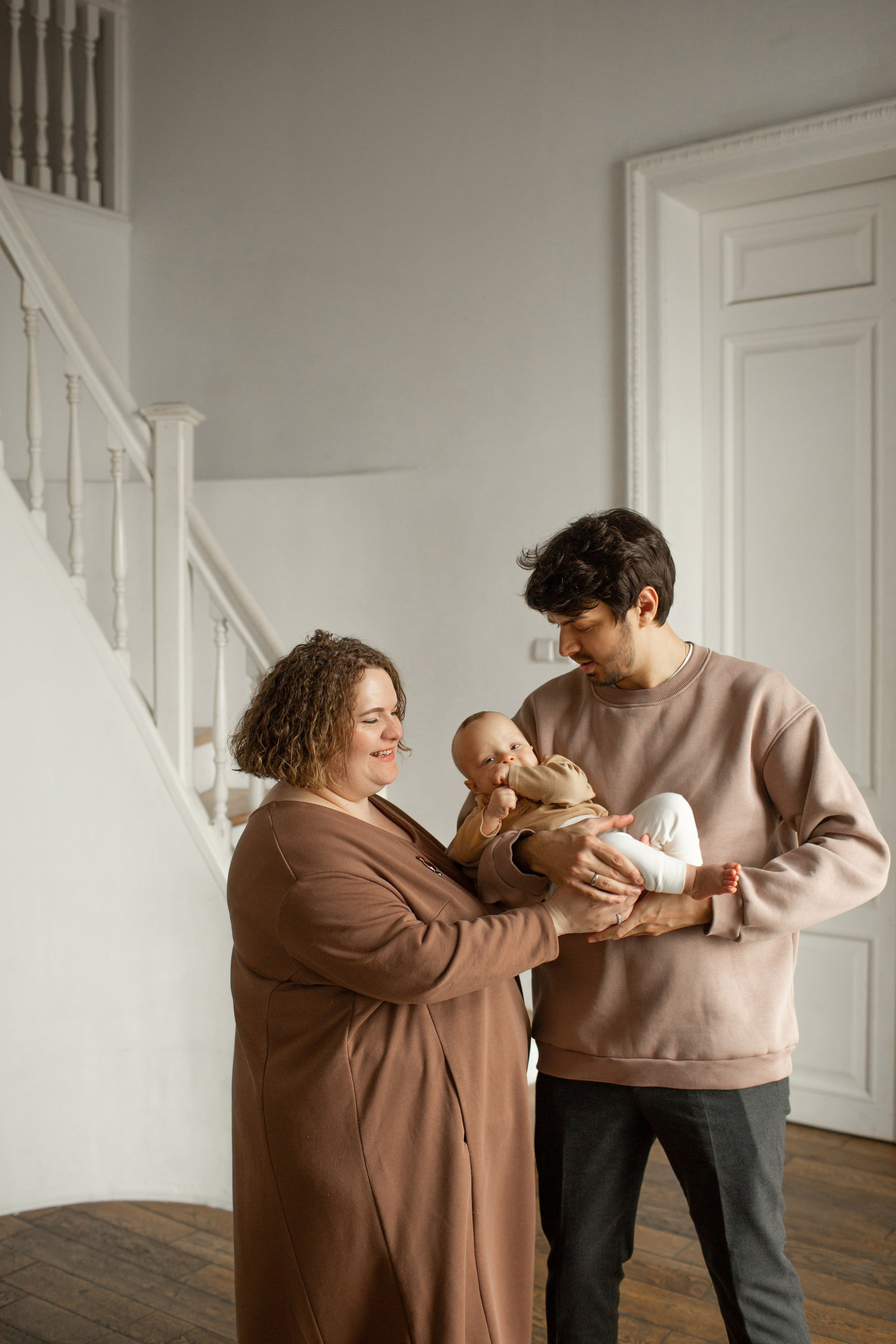 Уютный стиль для семейной съемки: мама в коричневом платье, папа в бежевой толстовке.