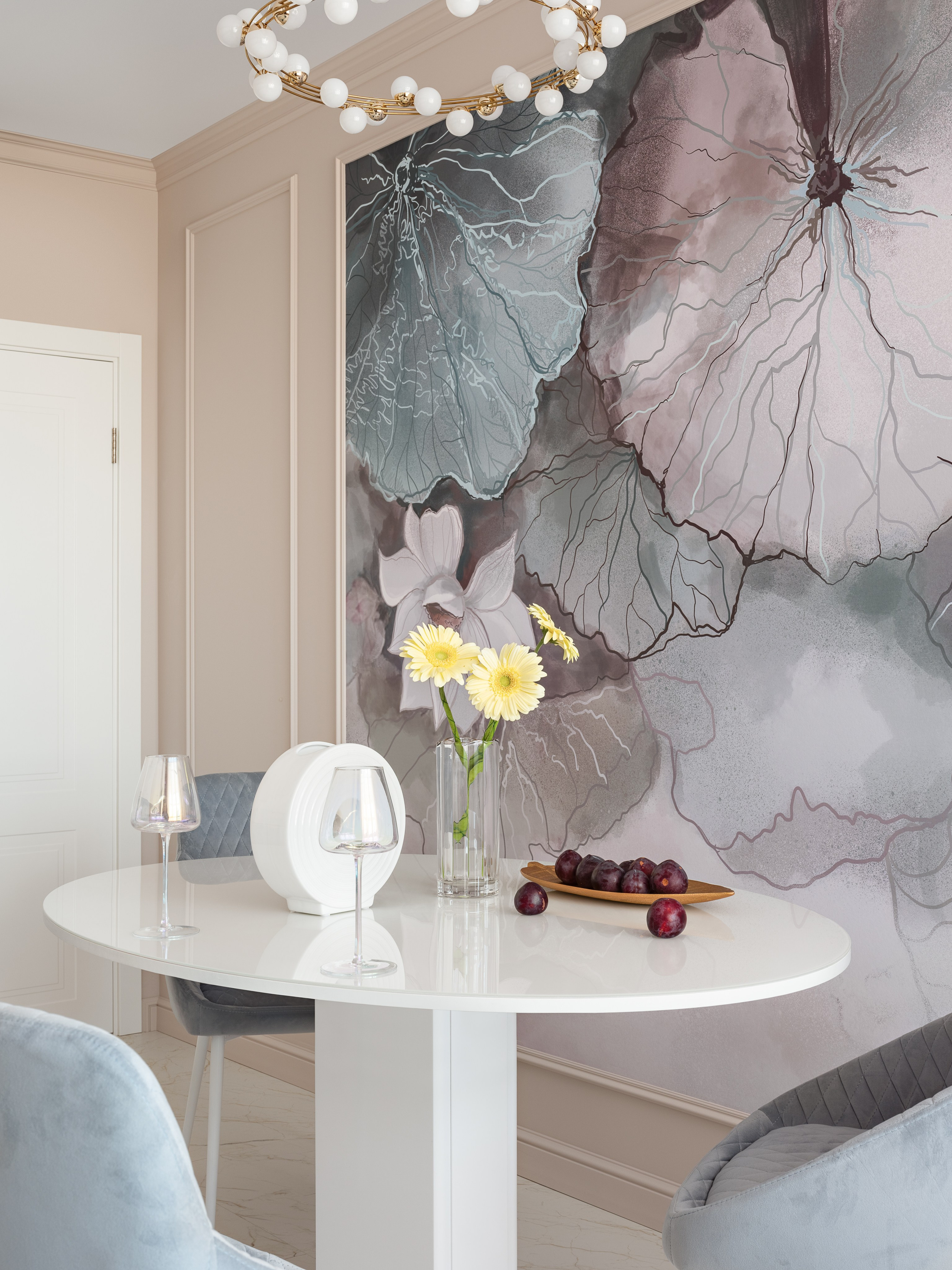 Элегантная обеденная группа с белым круглым столом, серыми стегаными стульями и акцентной настенной росписью в пастельных оттенках, дополненной стильной люстрой; атмосферу создали дизайнер Наталья Бунеева, стилист Наталья Якушева, фотограф Сергей Денисенко.