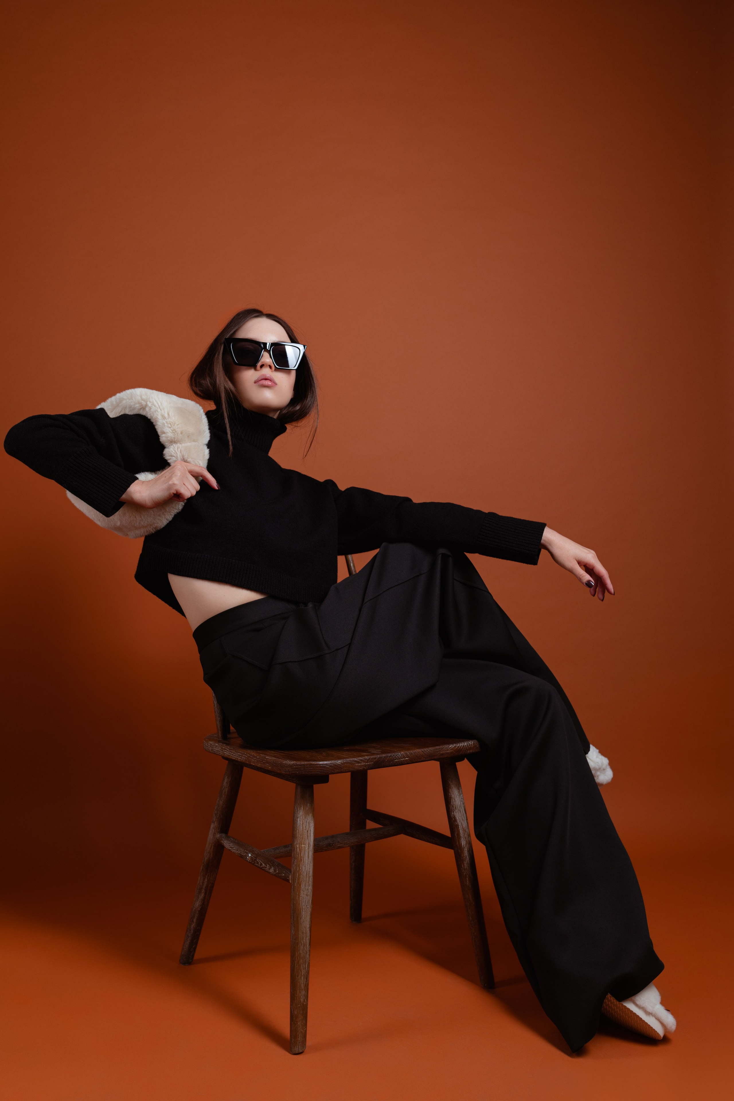 Фэшн портрет женщины на оранжевом фоне студии