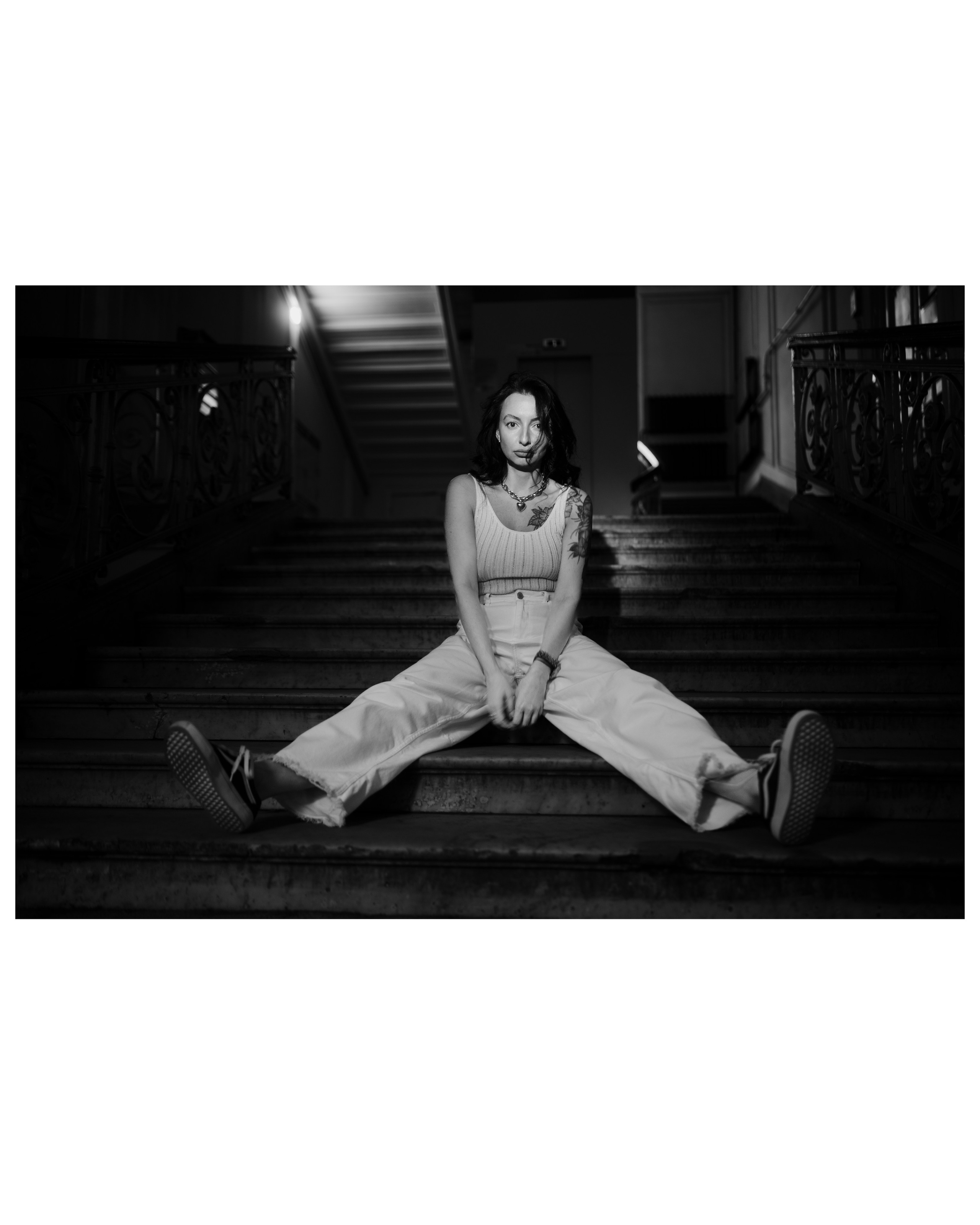 девушка сфотографирована сидящей на лестнице в санкт-петербургской парадной