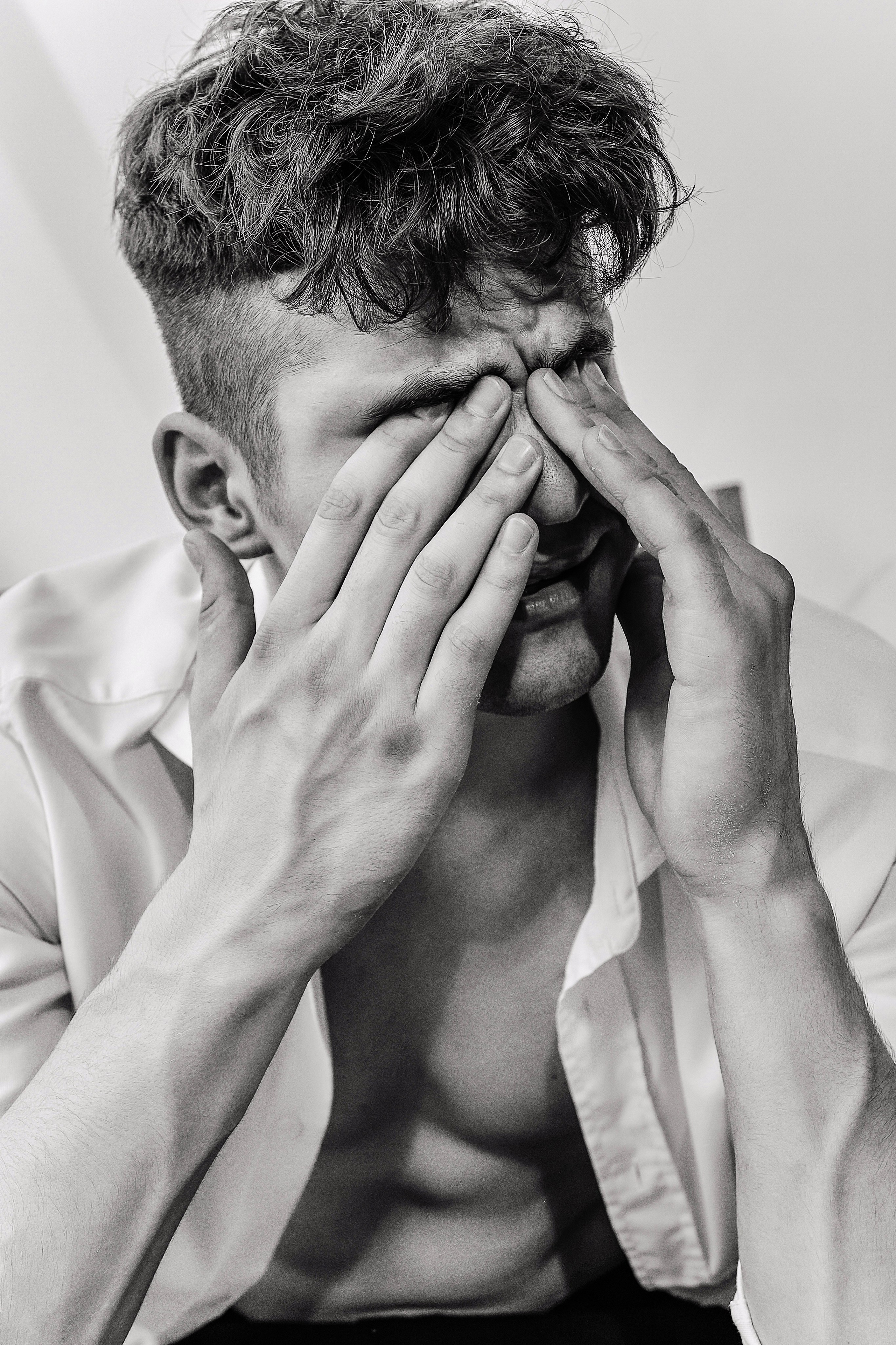 мужчина закрывает глаза 