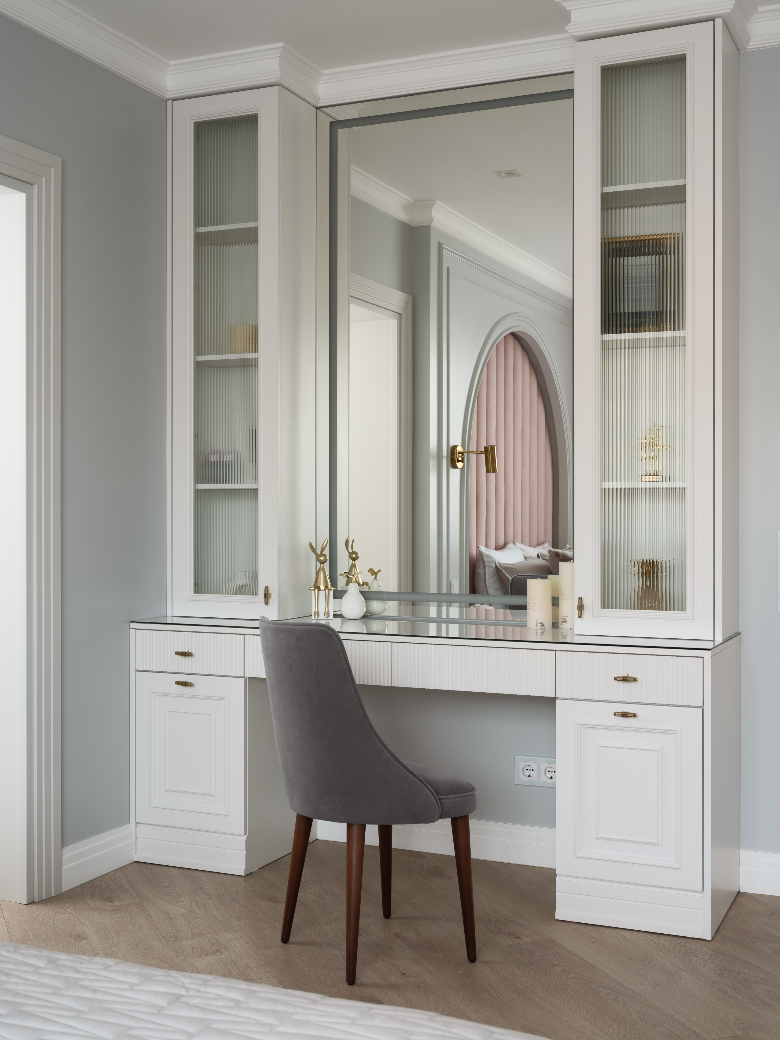 Белый встроенный туалетный столик с зеркалом в полный рост и мягким серым креслом. Минималистичный и светлый интерьер спальни в спокойных тонах. Проект дизайнера Евгении Ермошиной, съемка Сергея Денисенко.