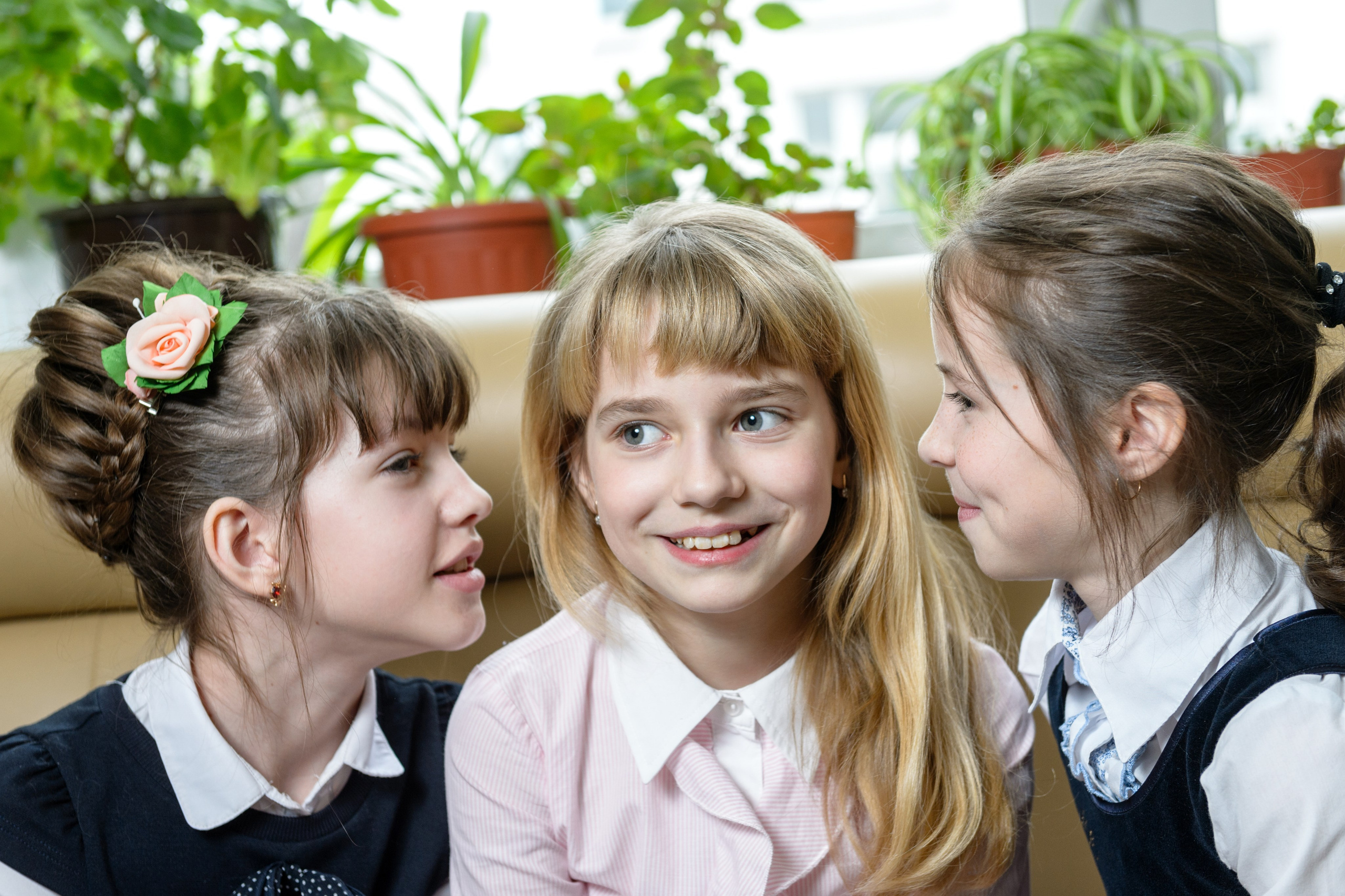 Три девочки общаются и улыбаются на школьной перемене