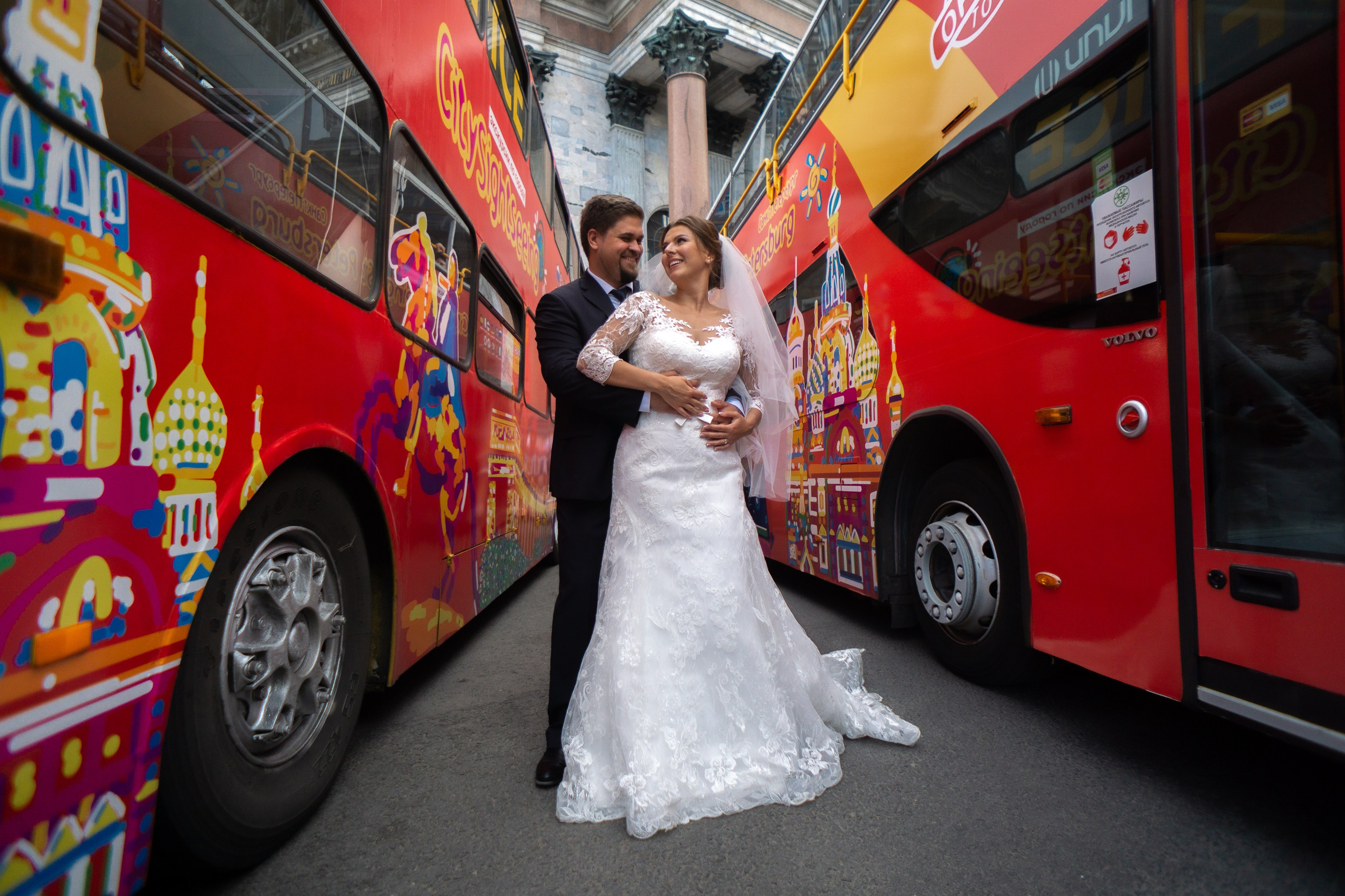 жених и невеста обнимаются между красными туристическими силами