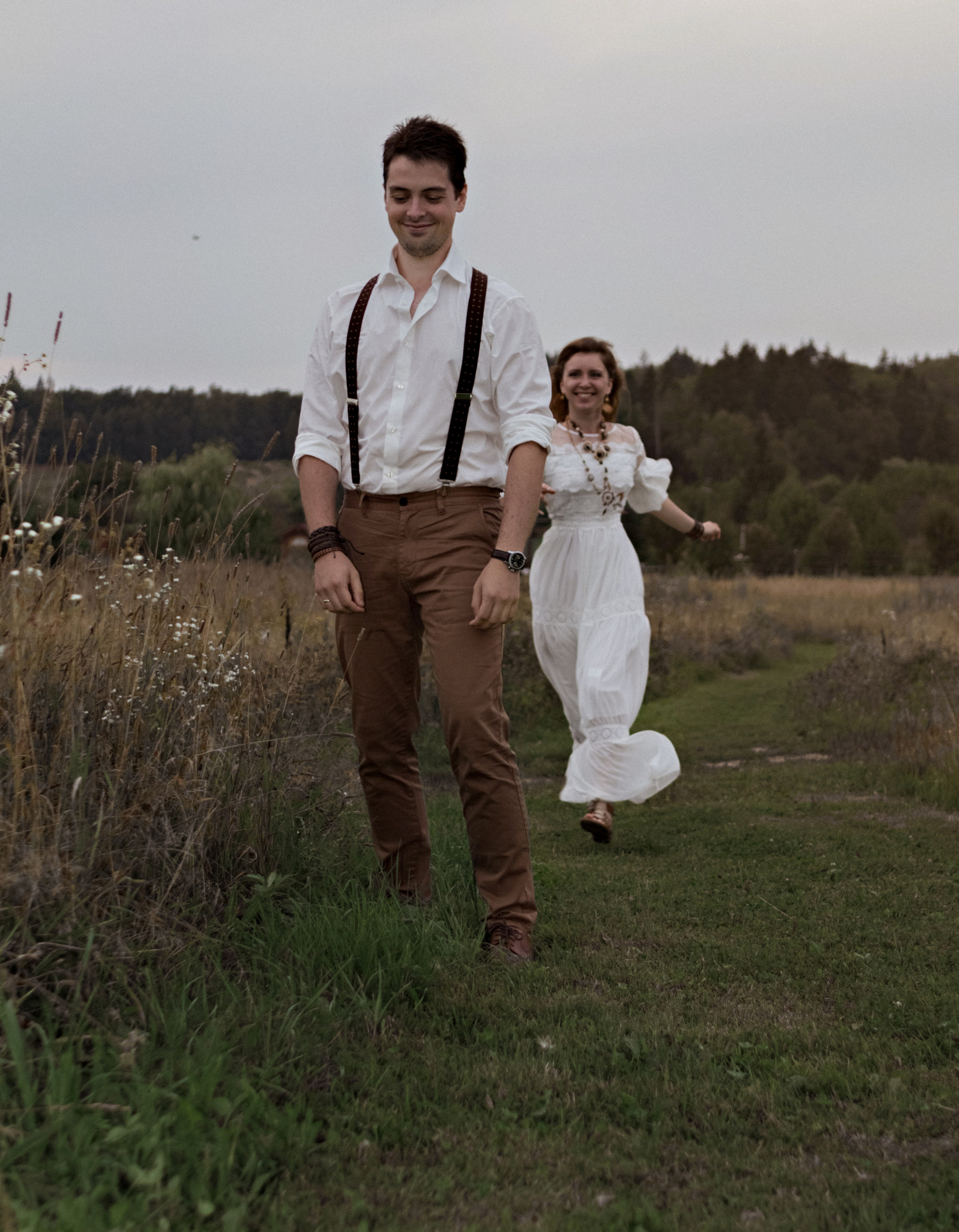 Девушка в белом бежит к мужчине по полю