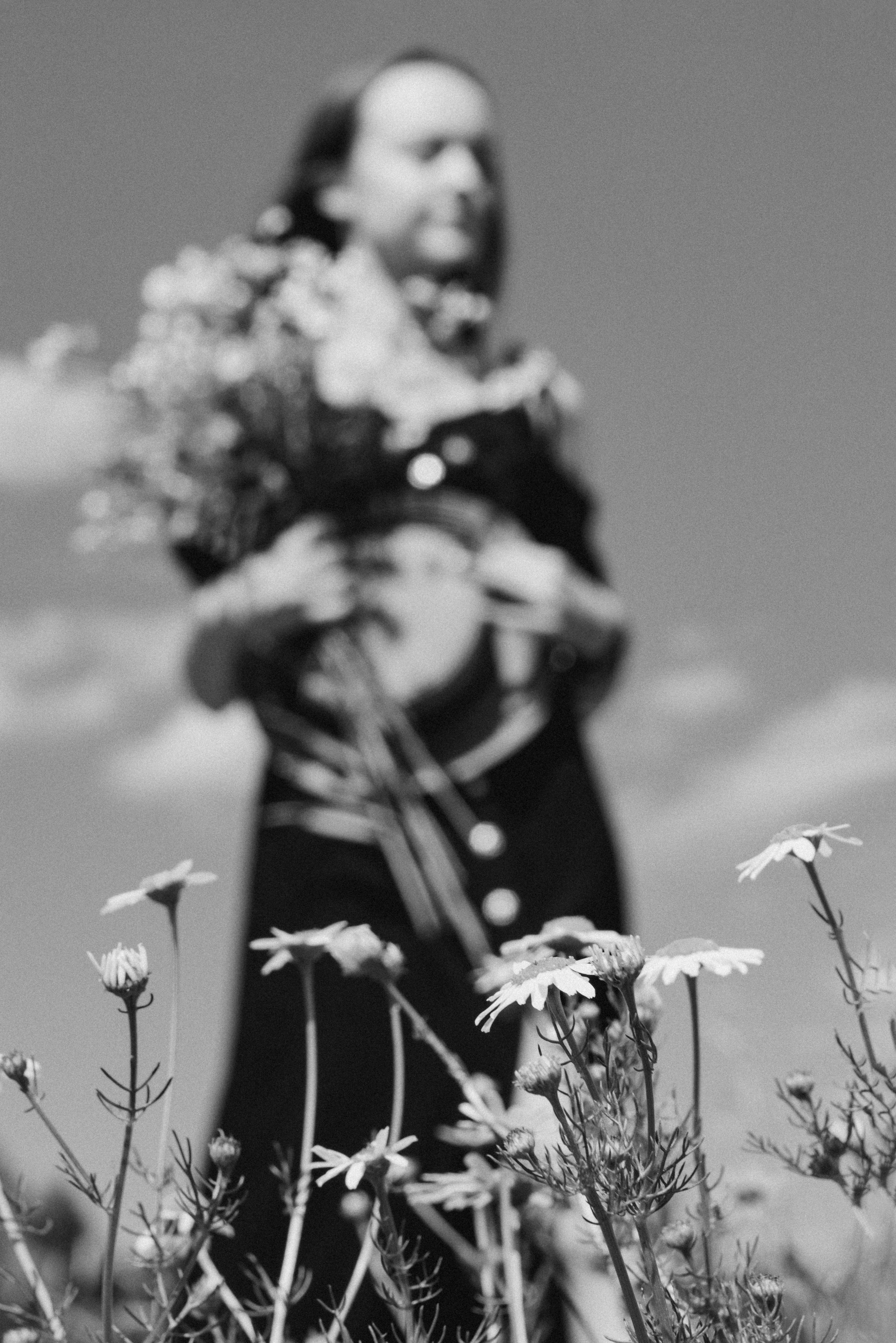 Девушка не в фокусе на фоне ромашек