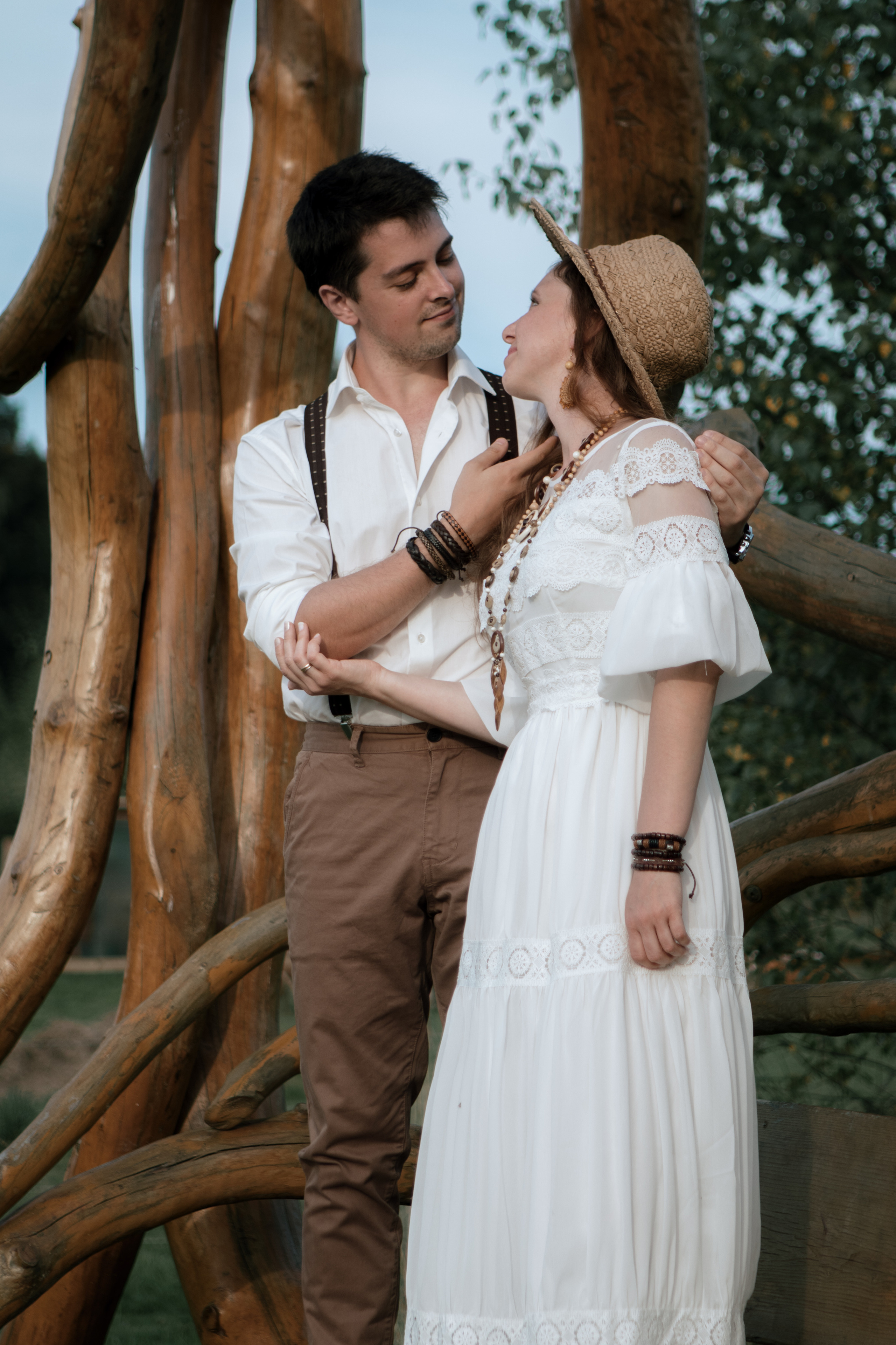 Влюбленная пара в белом на деревянных качелях