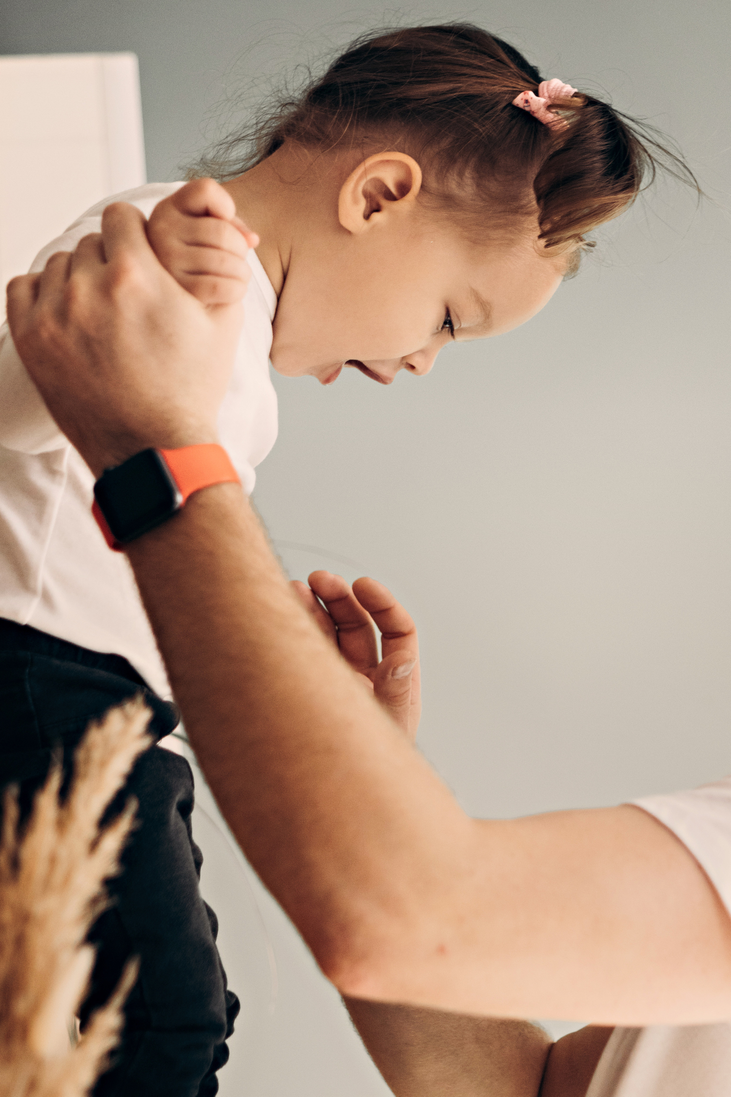 Папа держит маленькую дочку за руки