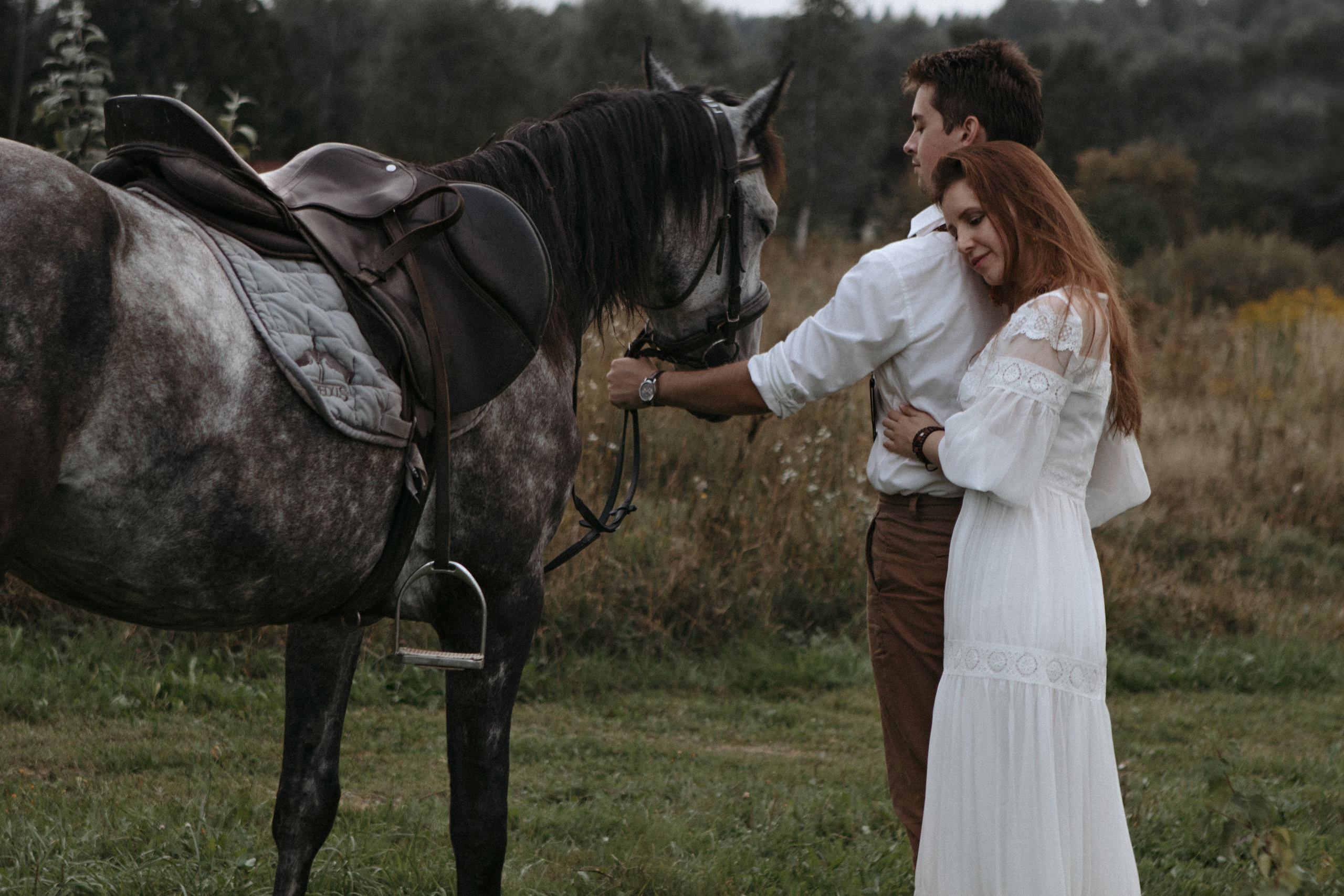 Влюбленная пара в белом рядом с конем
