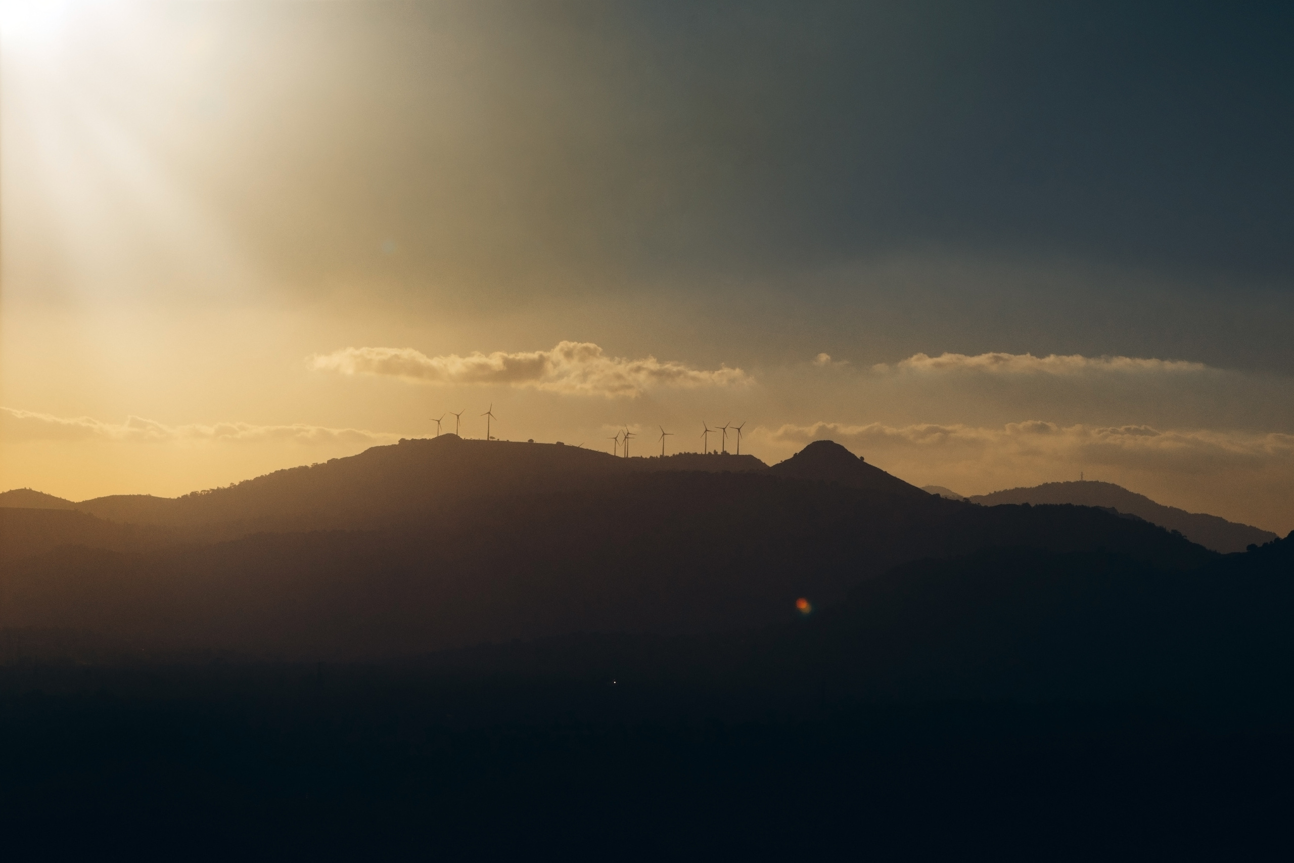 Горы с ветряными мельницами в закатный час