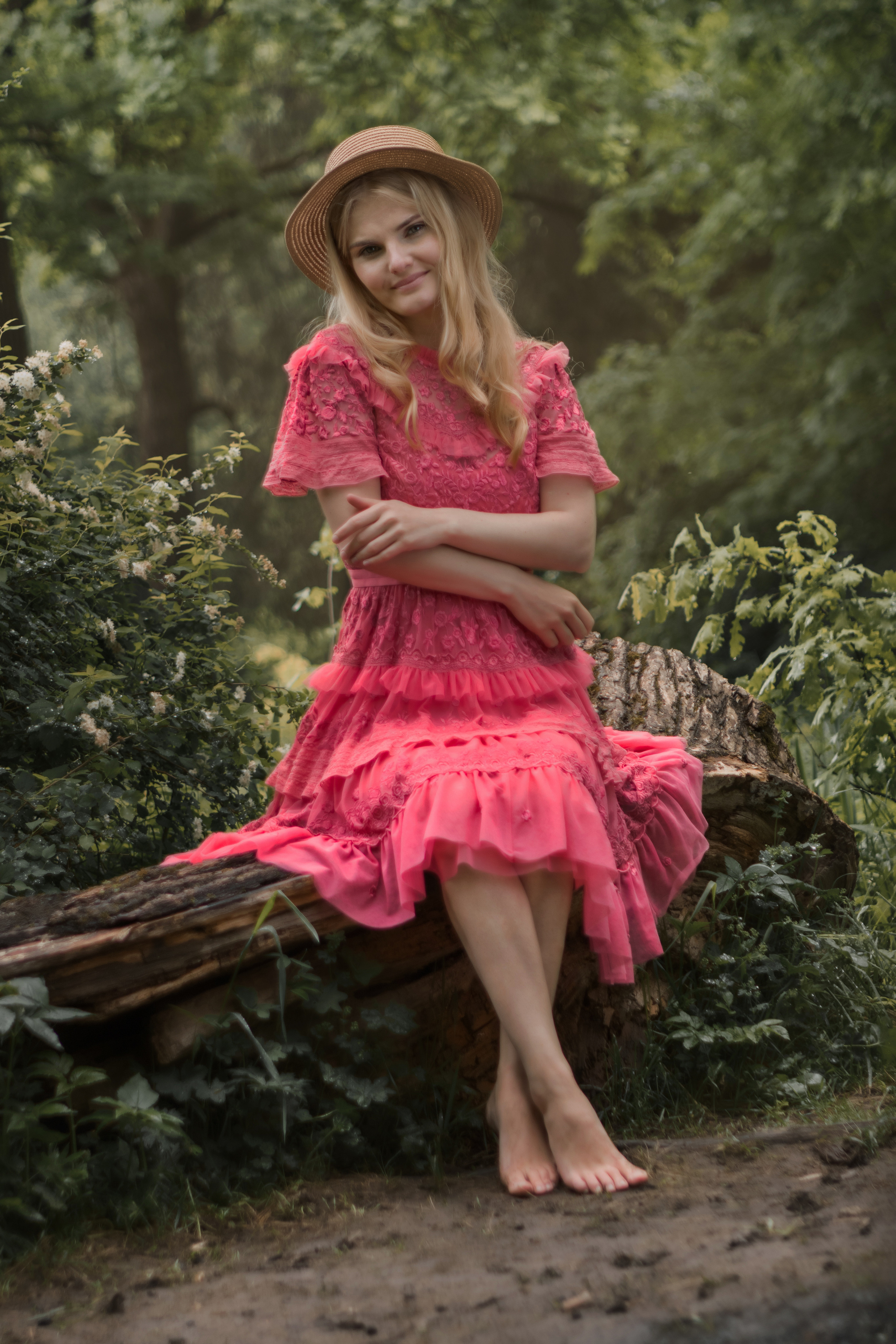 Девушка в розовом платье в лесу на пеньке