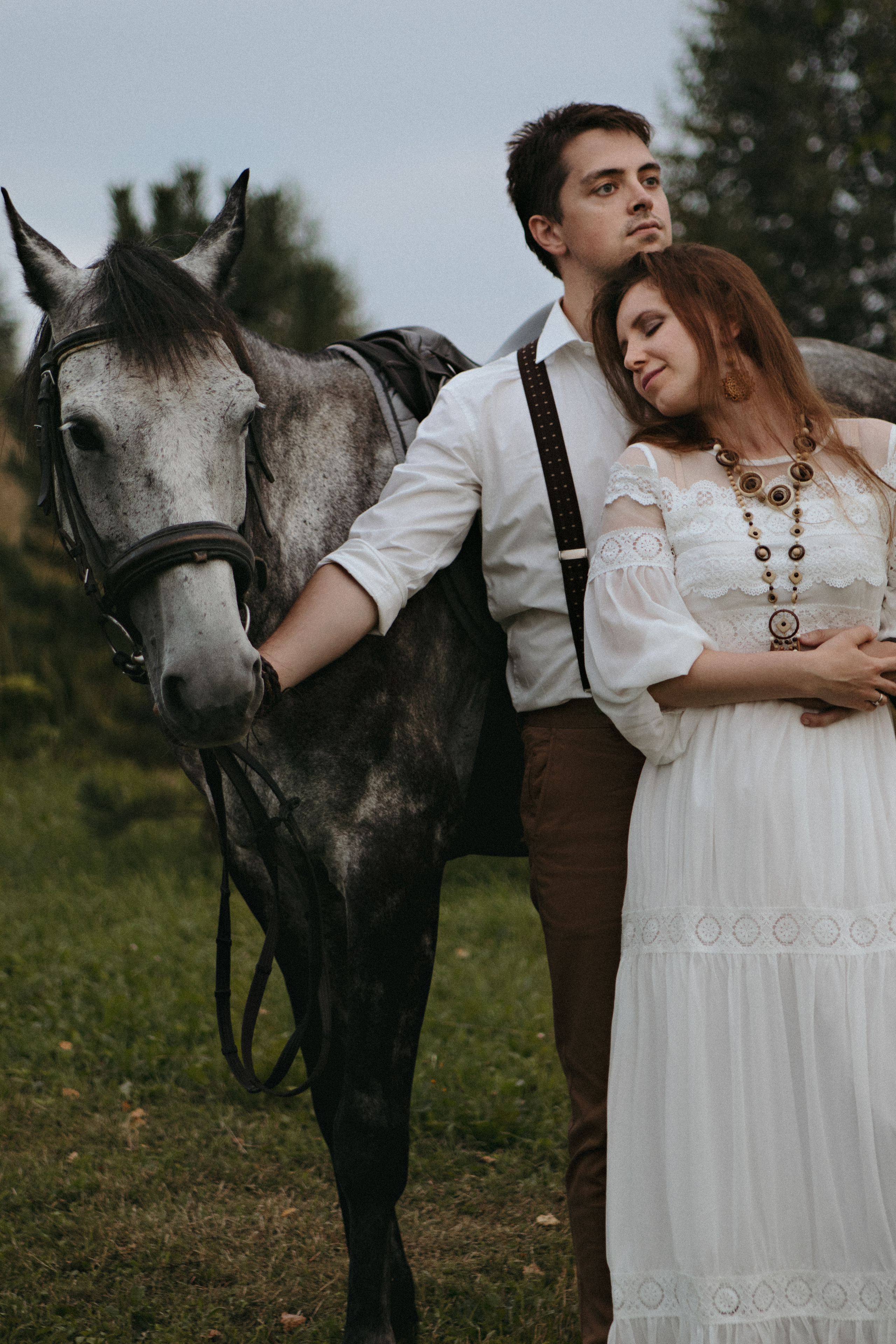 Влюбленная пара в белом рядом с конем 