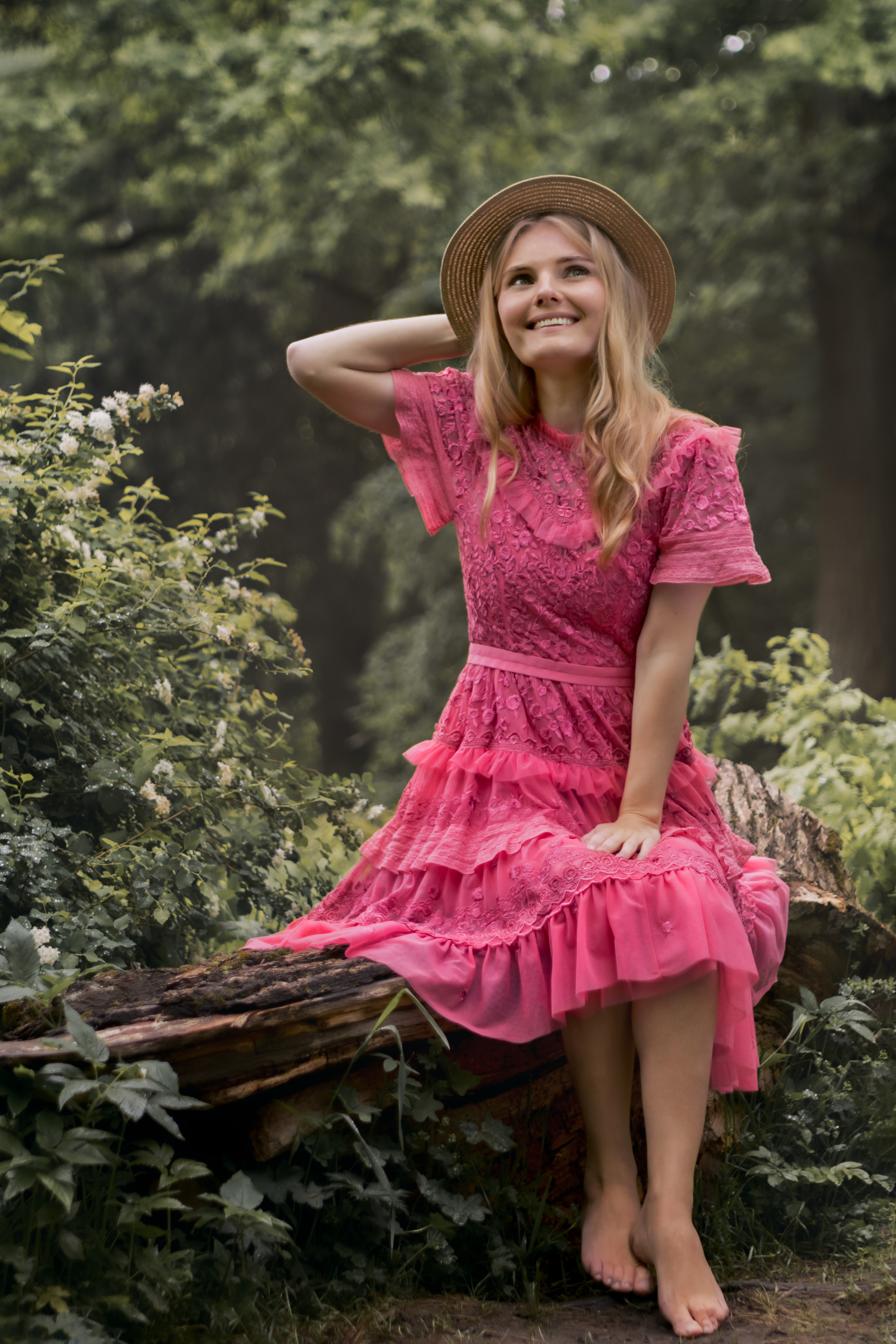 Девушка в розовом платье в лесу на пеньке