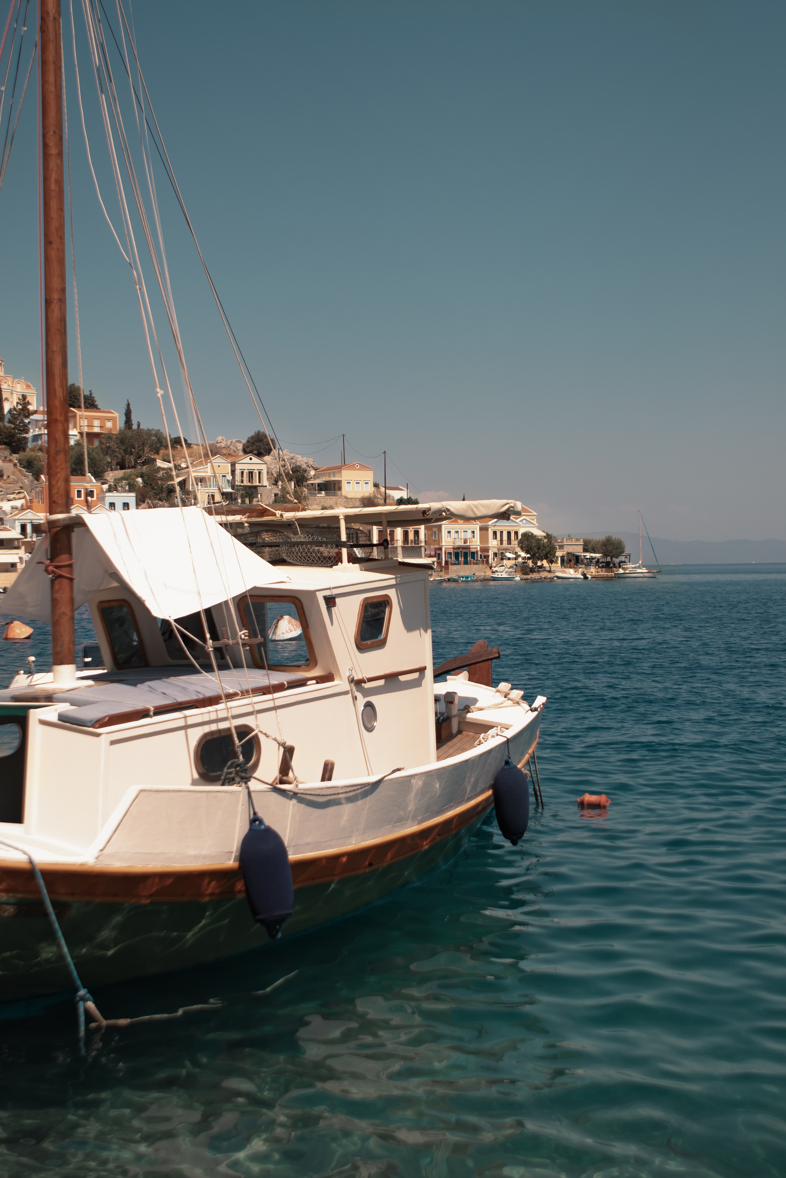 Белая яхта на фоне города и моря