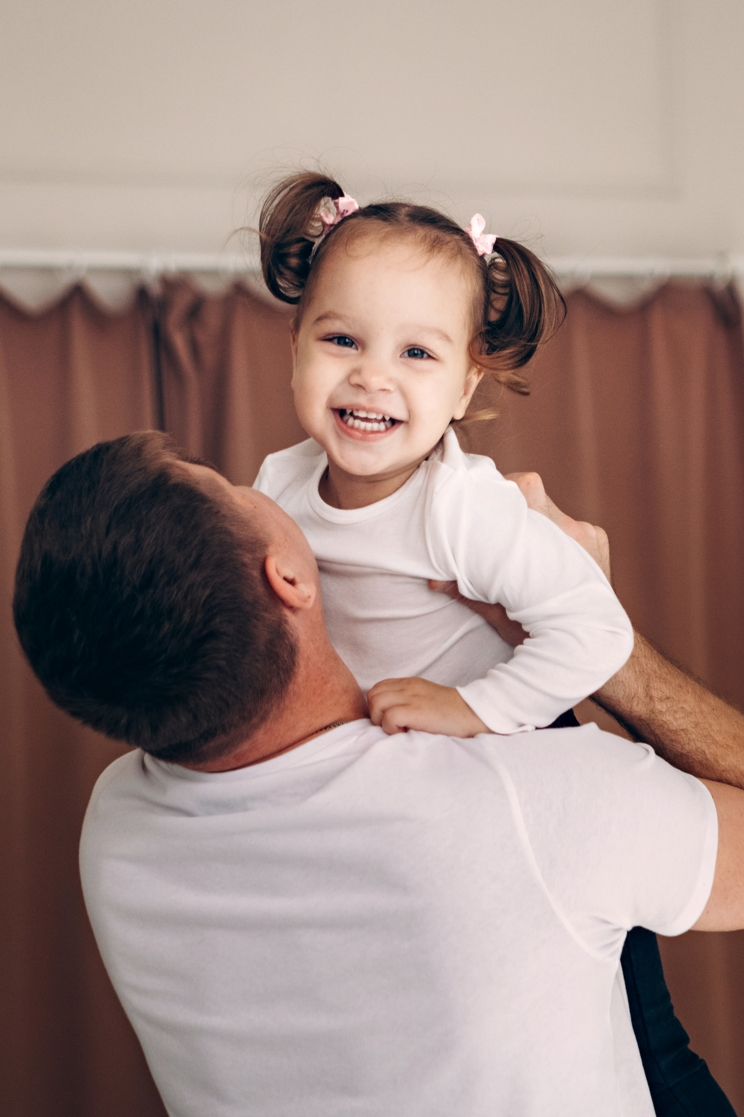 Папа держит на руках  маленькую дочку