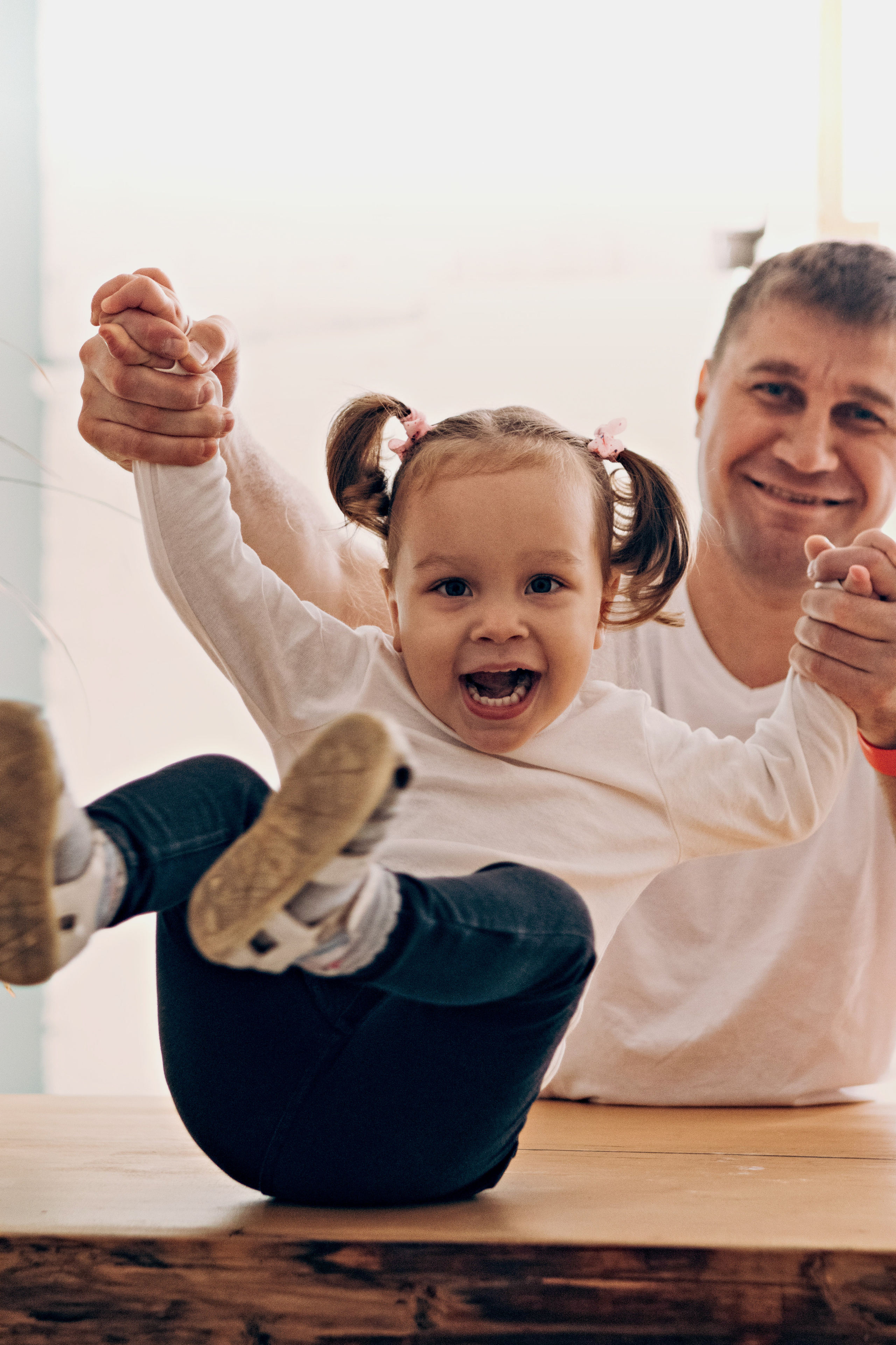 Папа держит маленькую дочку за руки