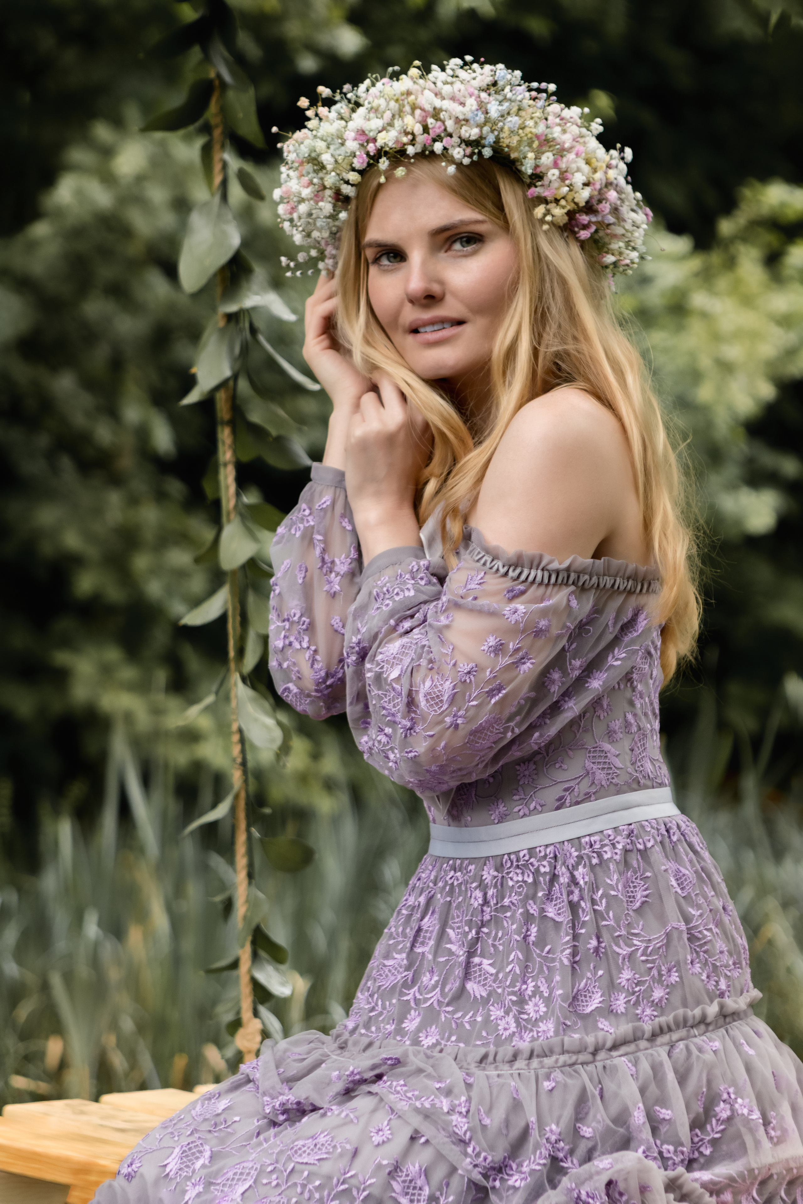 Девушка в сиреневом платье с венком на голове в лесу