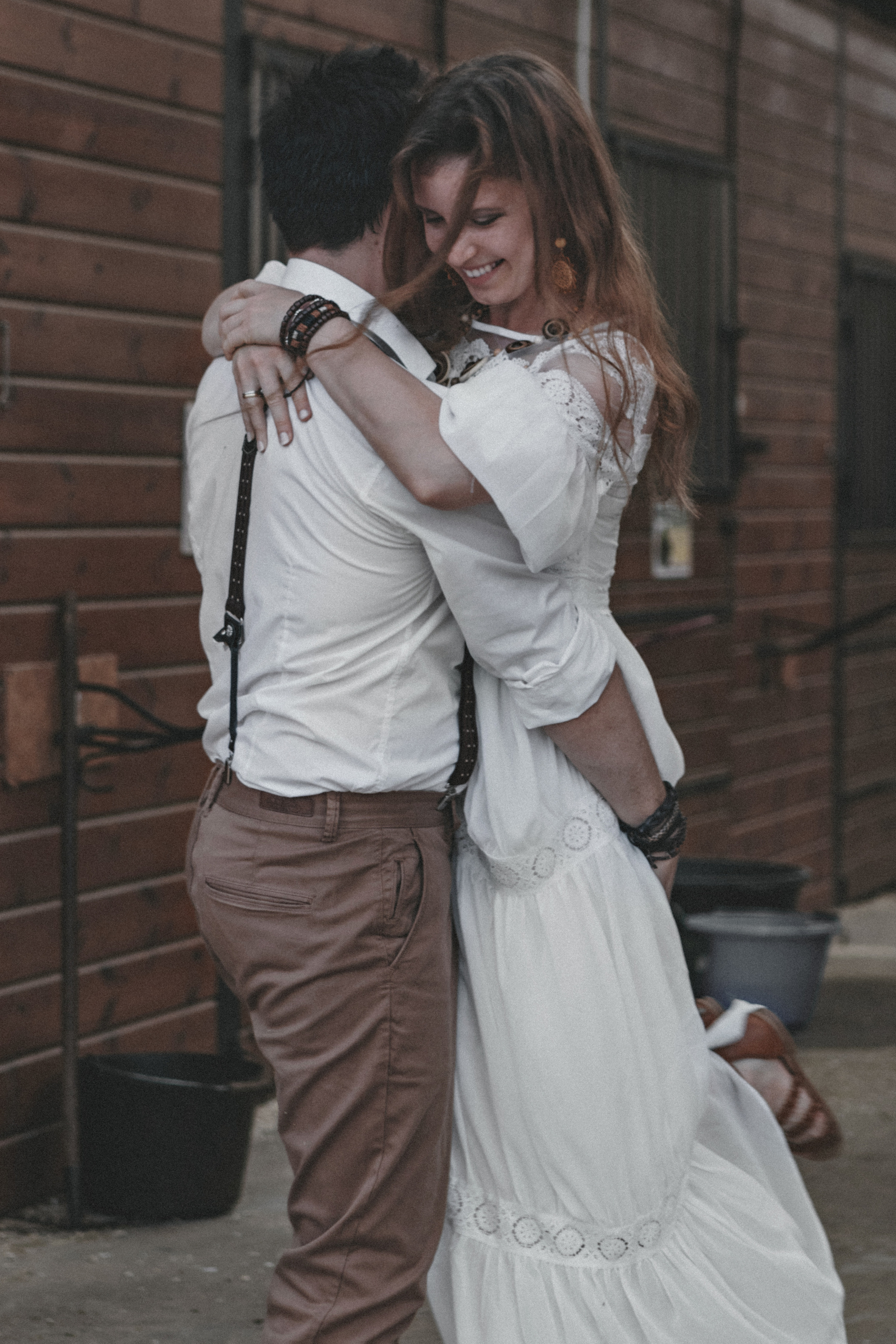 Влюбленная пара в белом кружаться на конюшне