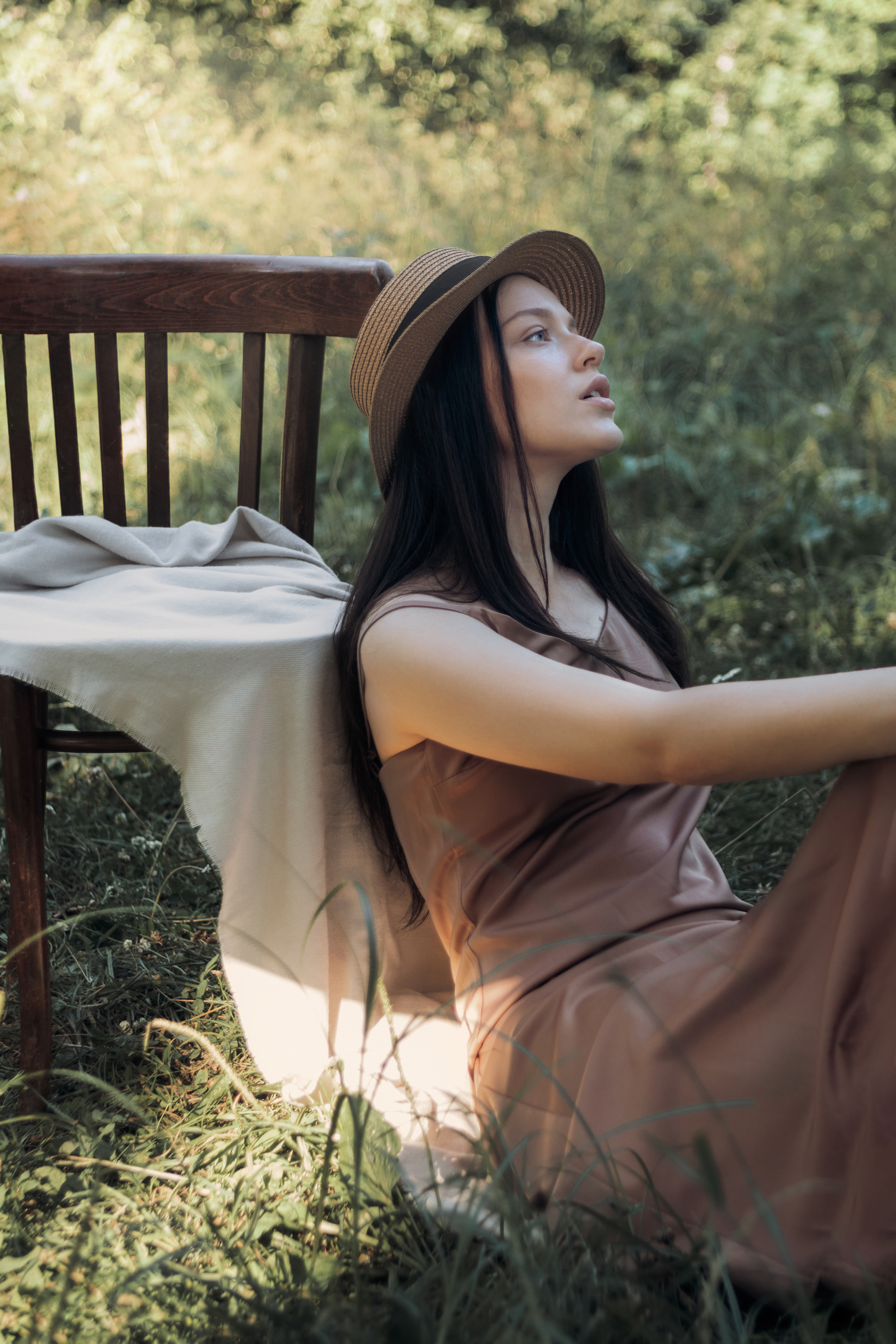 Девушка в шляпе на природе около стула