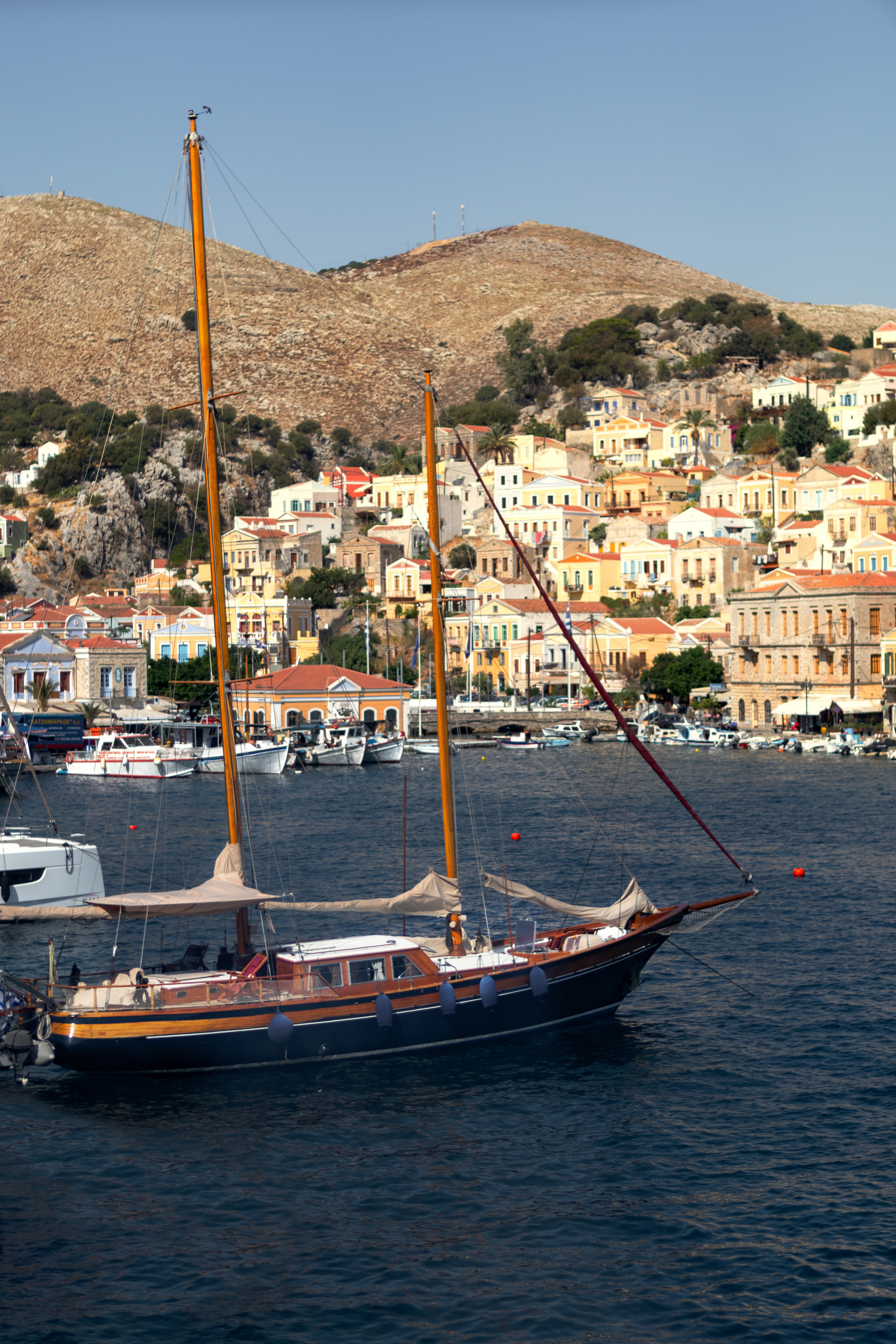 Парусная лодка на фоне гор и города