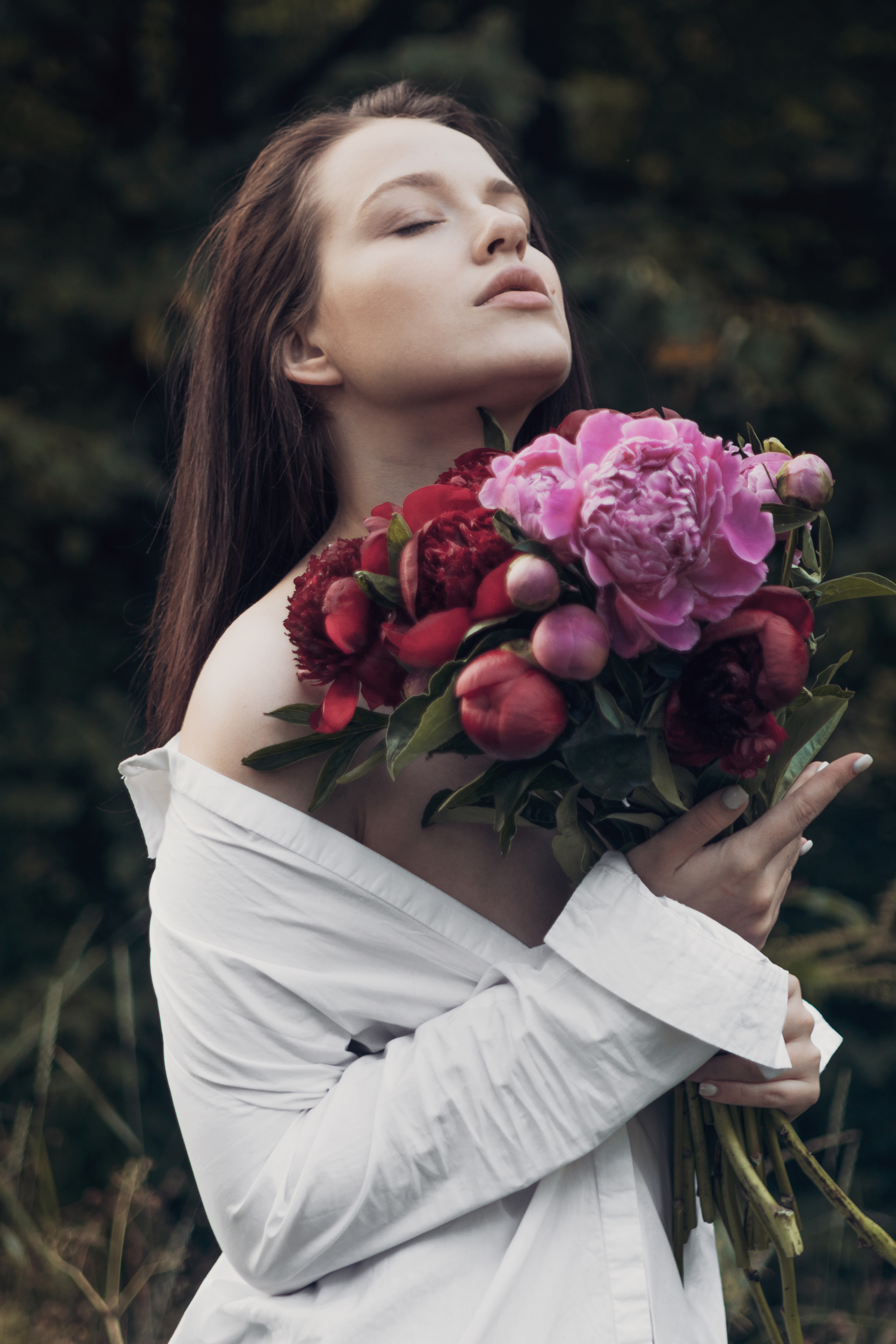 Девушка в белой рубашке с букетом пионов