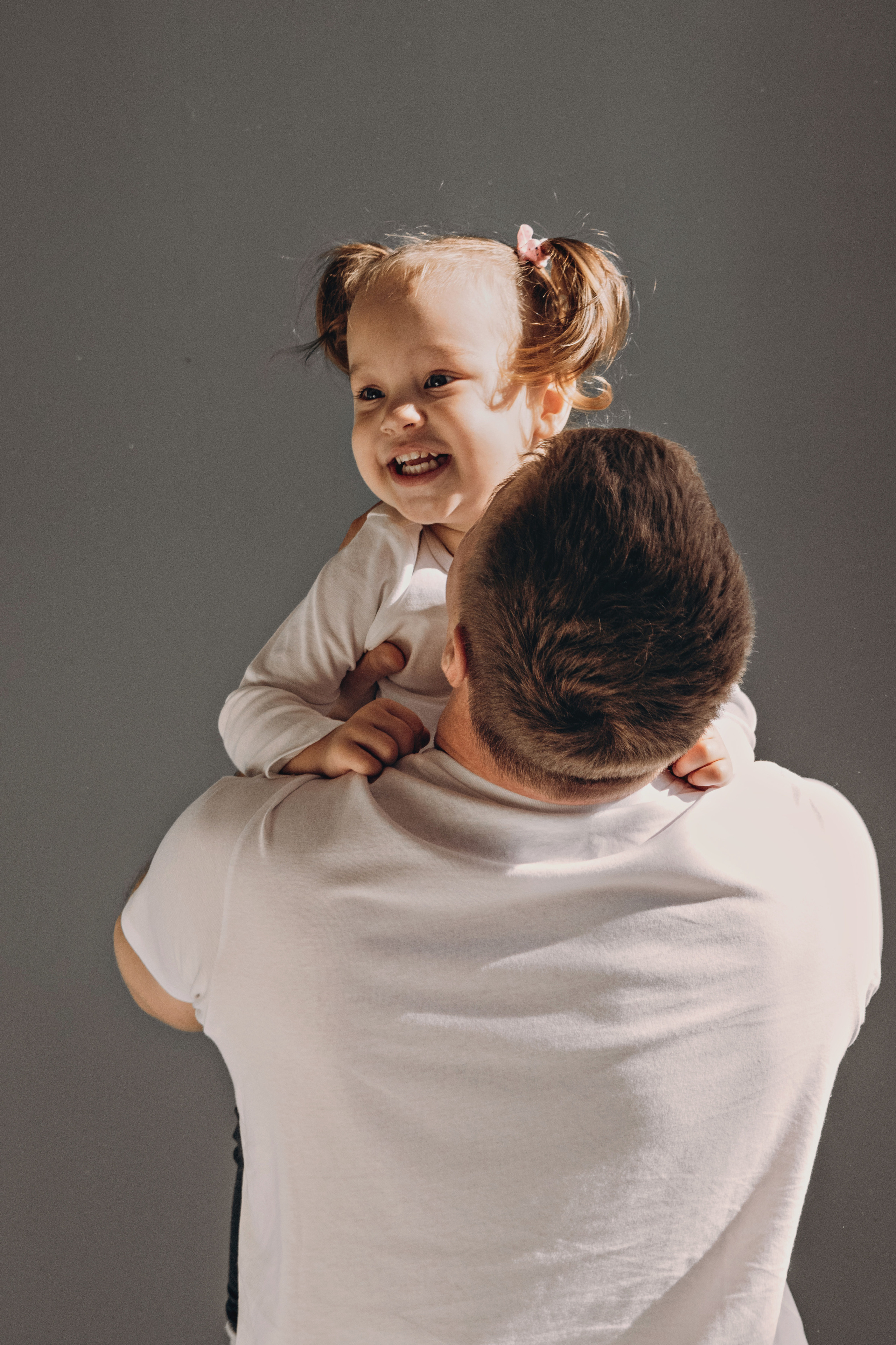 Папа держит на руках  маленькую дочку. 