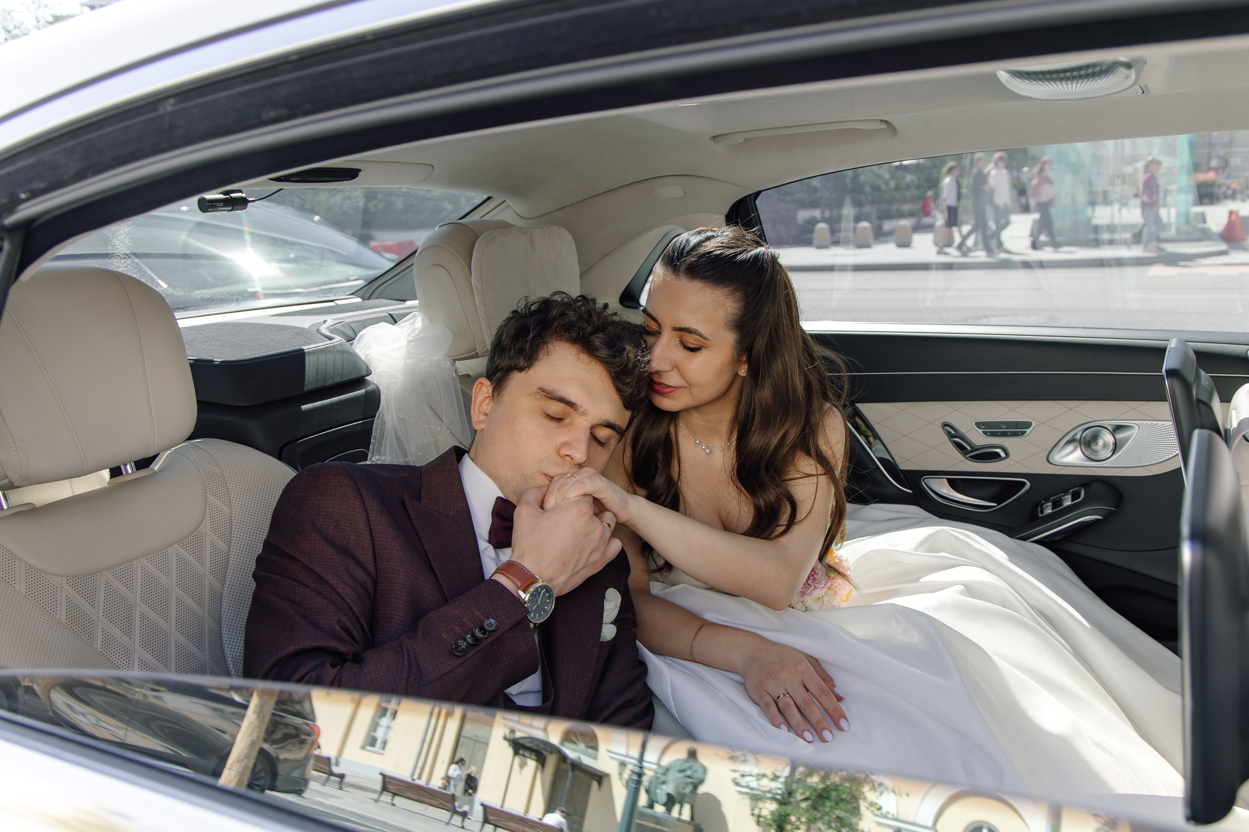 Жених и невеста на свадебной фотосессии с автомобилем