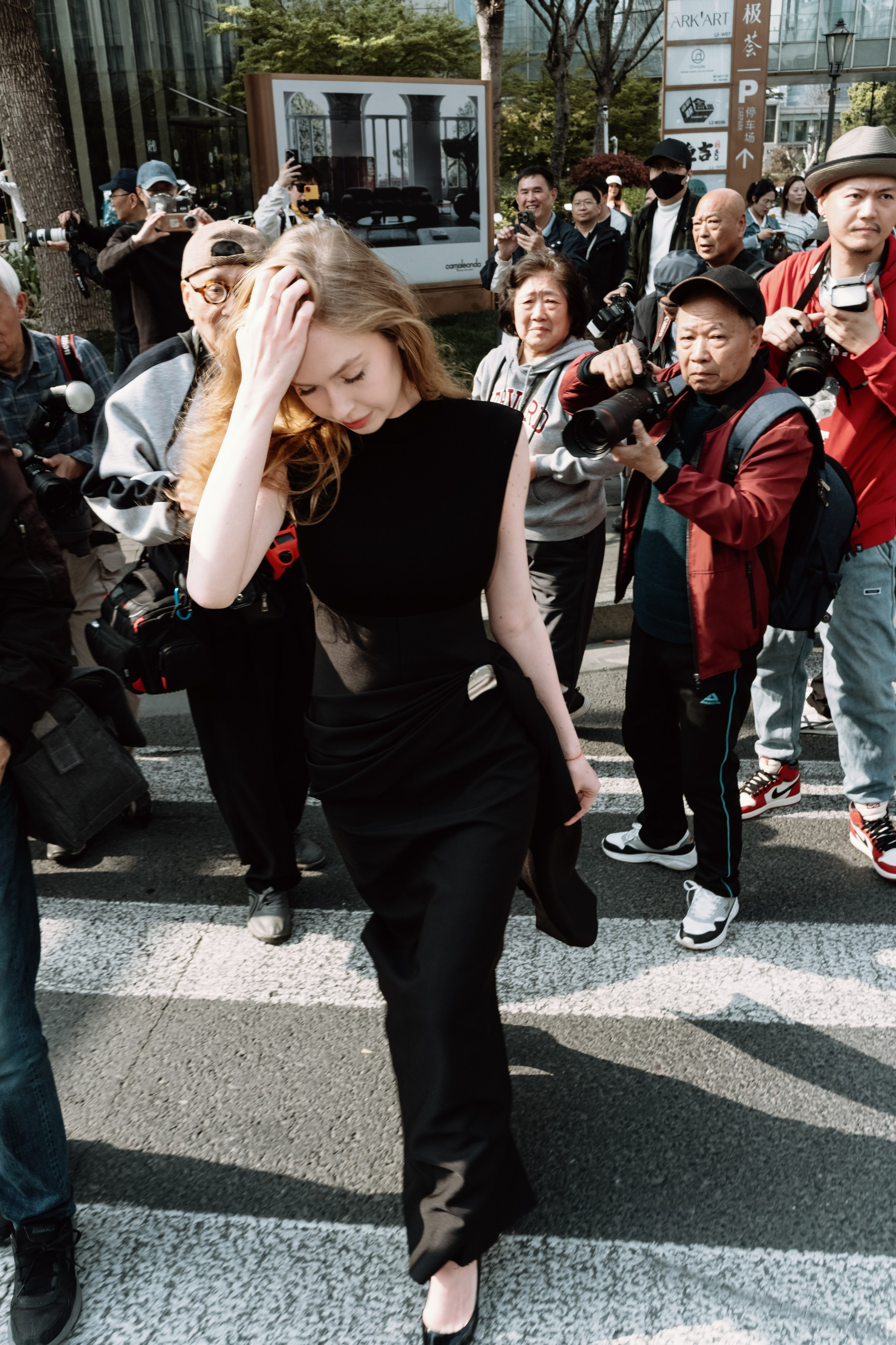 Блогера Ханну окружают китайские фотографы на улицах Шанхая, момент популярности и внимания.