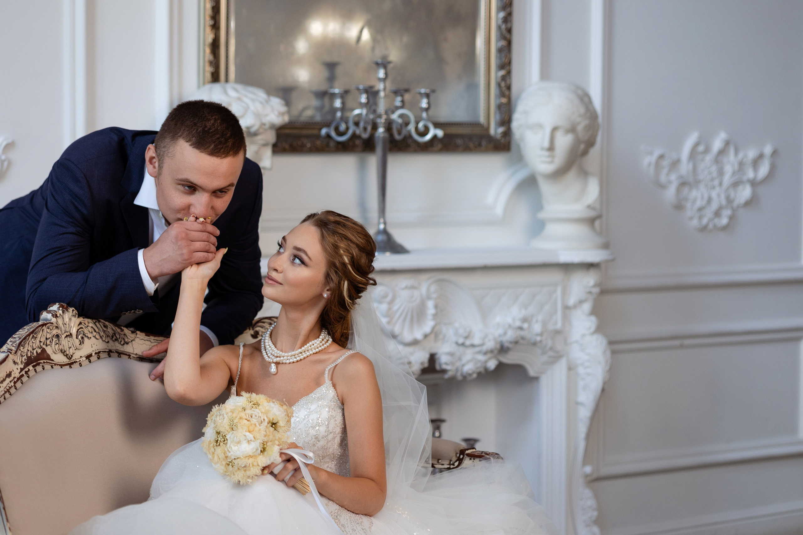 Жених наклонился над невестой, целуя ей руку