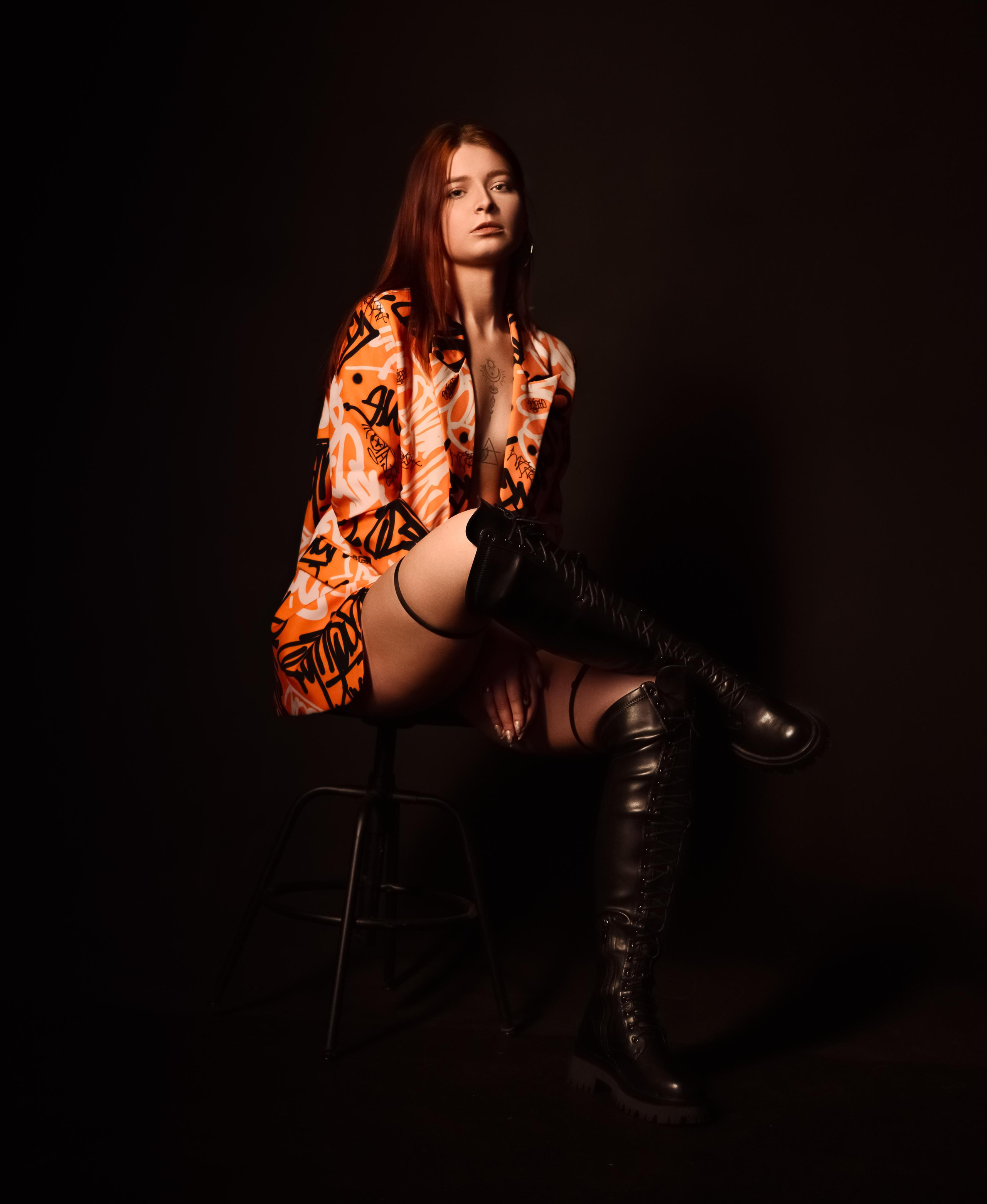 Студийная фотосессия девушки в пиджаке и сапогах