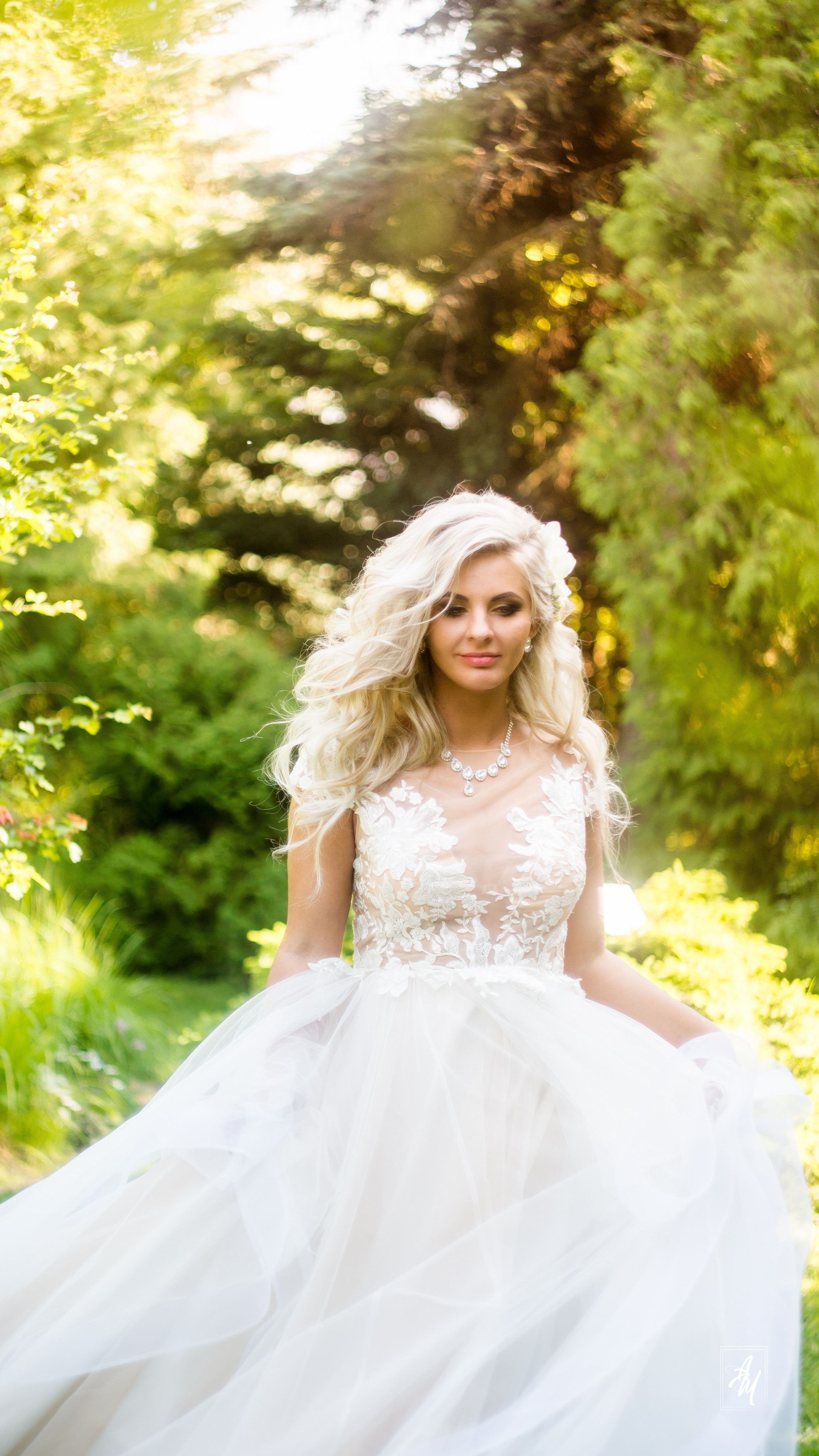 Невеста прогуливается по траве приподнимая платье