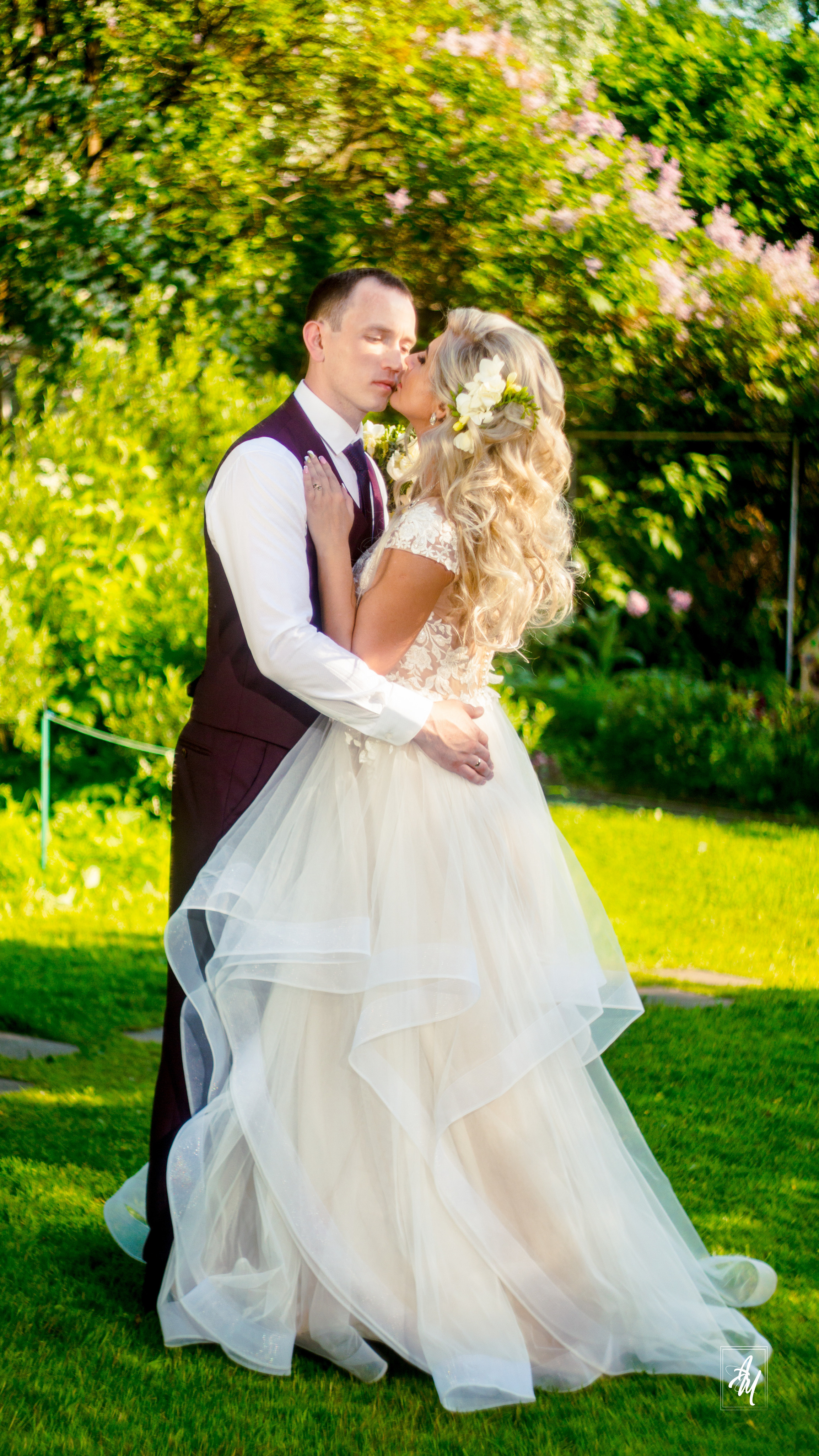 Жених с Невестой на небольшой лужайке объятья и поцелуй.