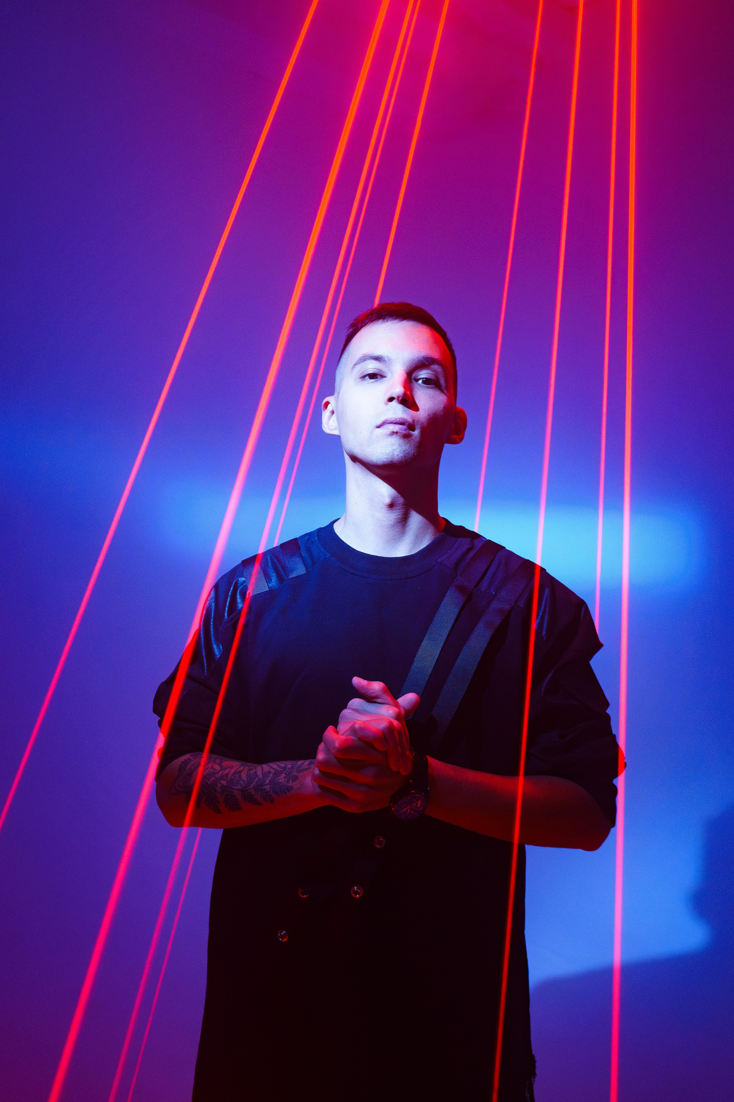 Портрет мужчины в лазерном свете с красно-синим фоном