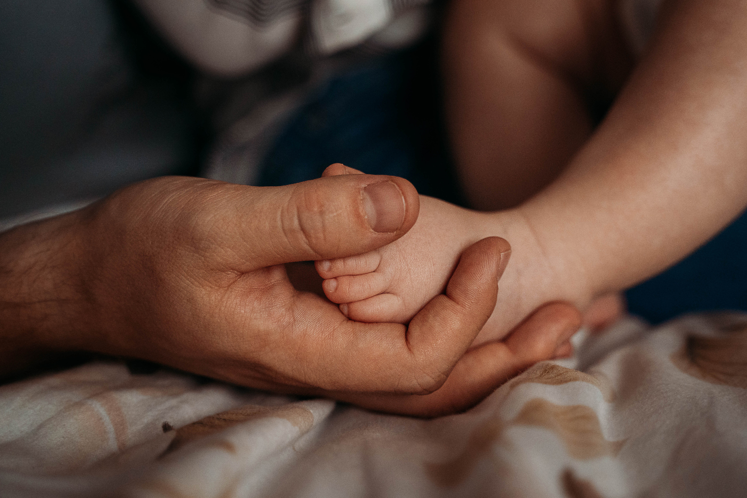 фотография с изображением крупным планом ножки малыша в руке у папы