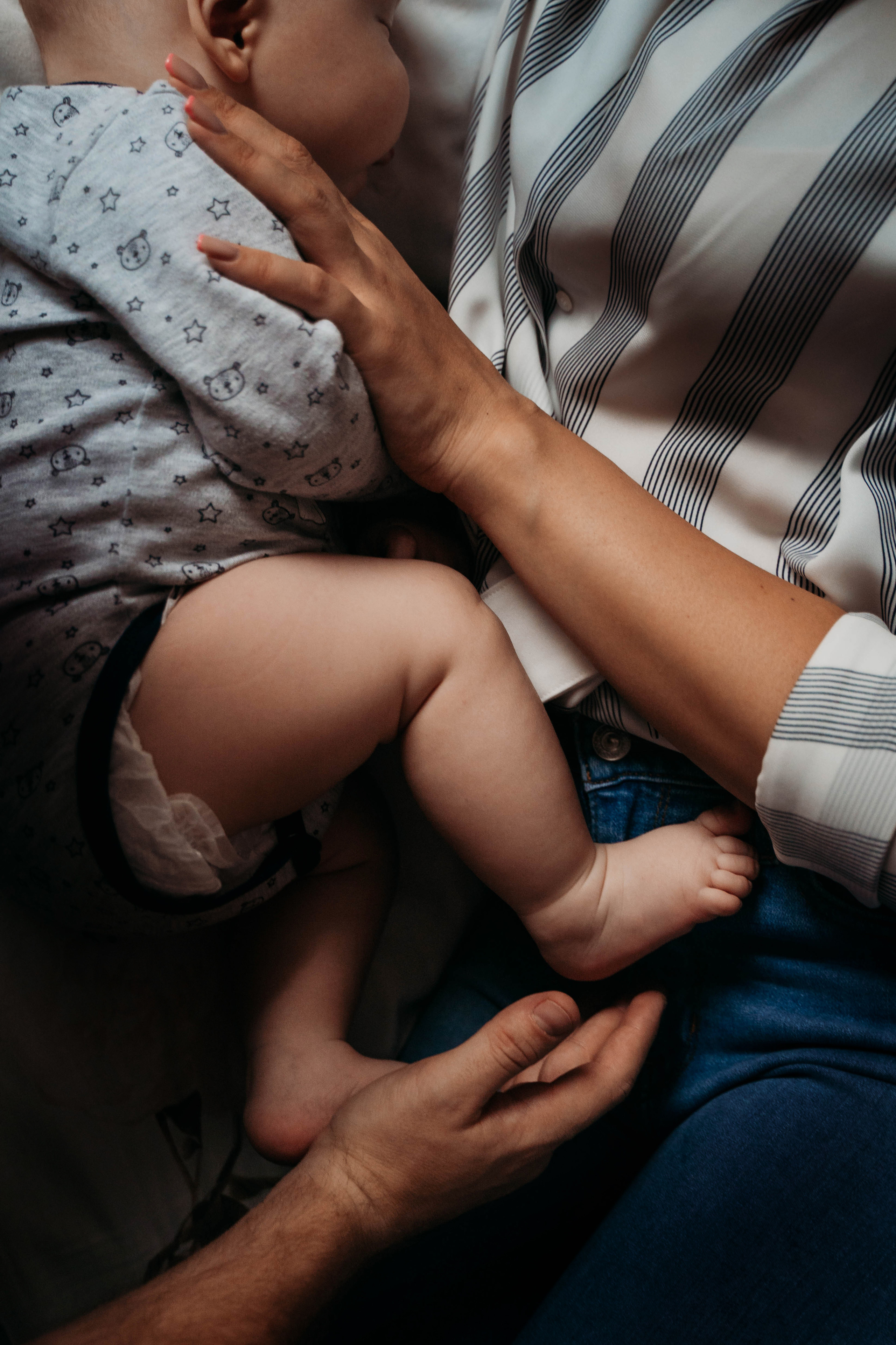 Фотография с крупным планом ножек малыша и рук мамы и папы