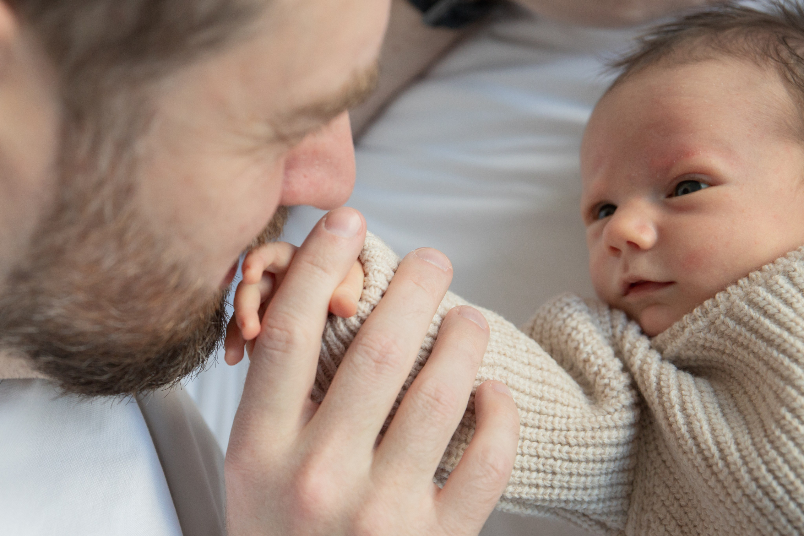 Фотограф новорожденных снимает первые семейные моменты родителей с маленьким ребенком дома.