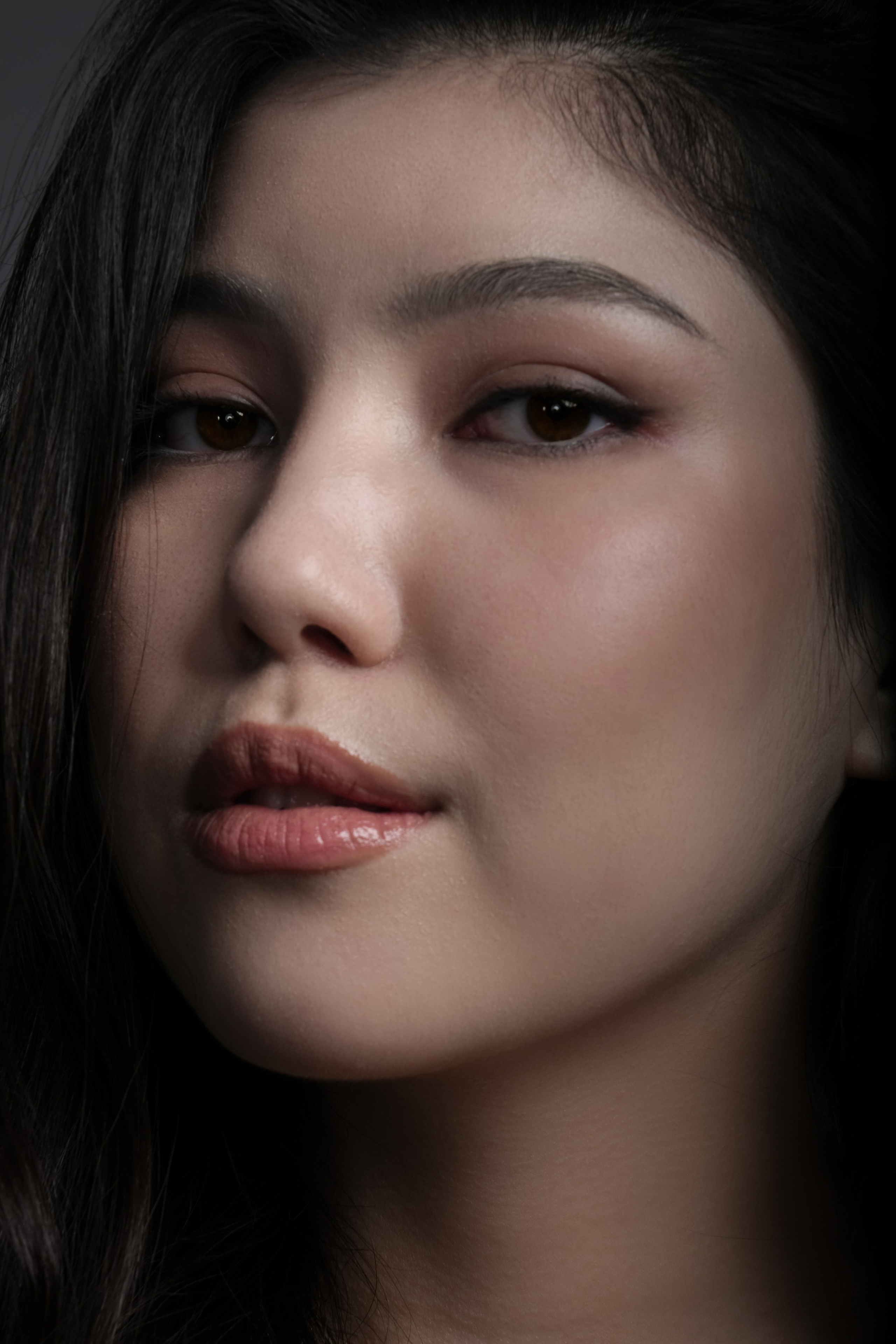 Портрет женщины в студии с мягким освещением — крупный план женщины с естественным макияжем и мягким освещением.