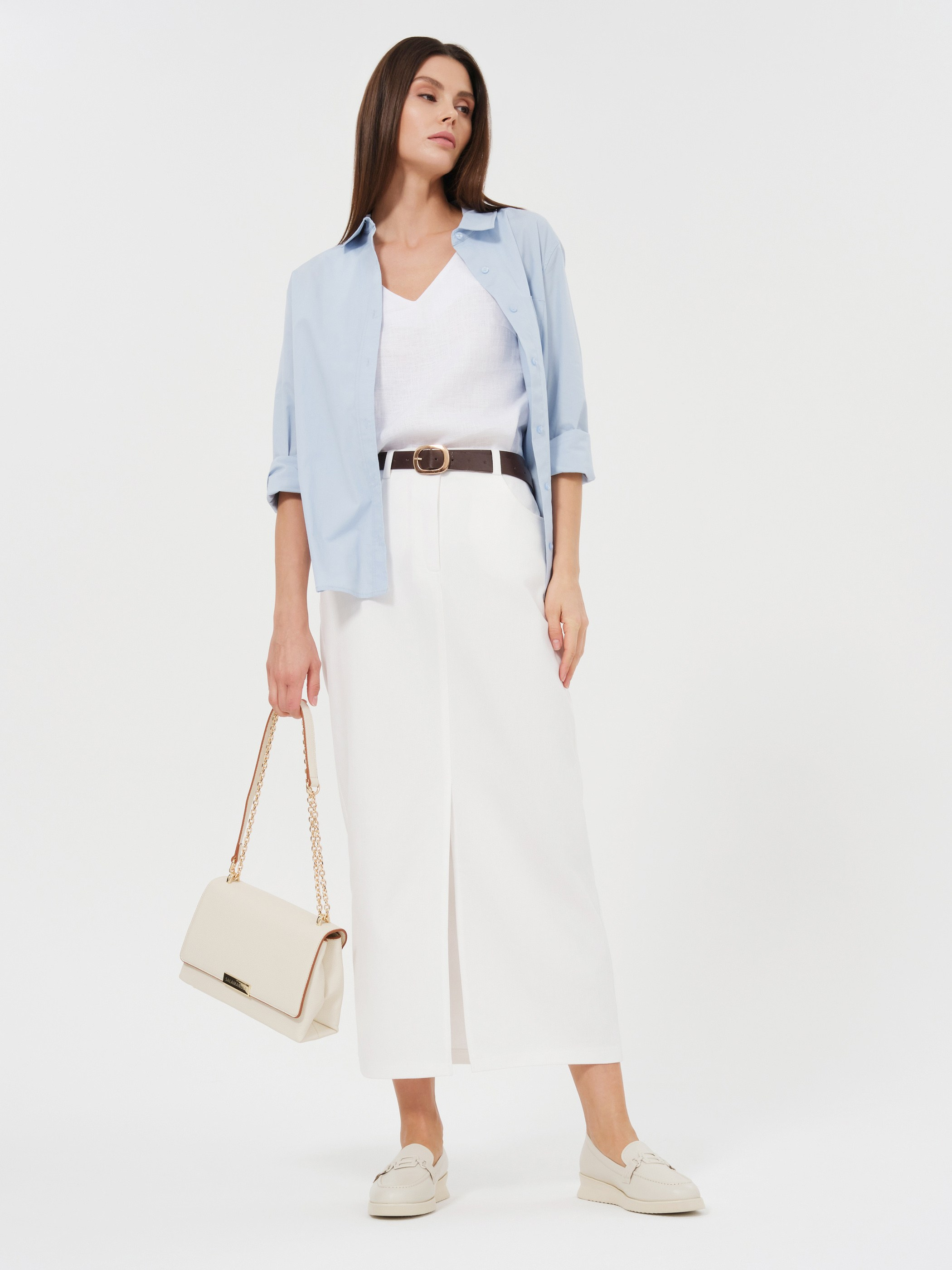 Женщина в голубой рубашке и белой юбке