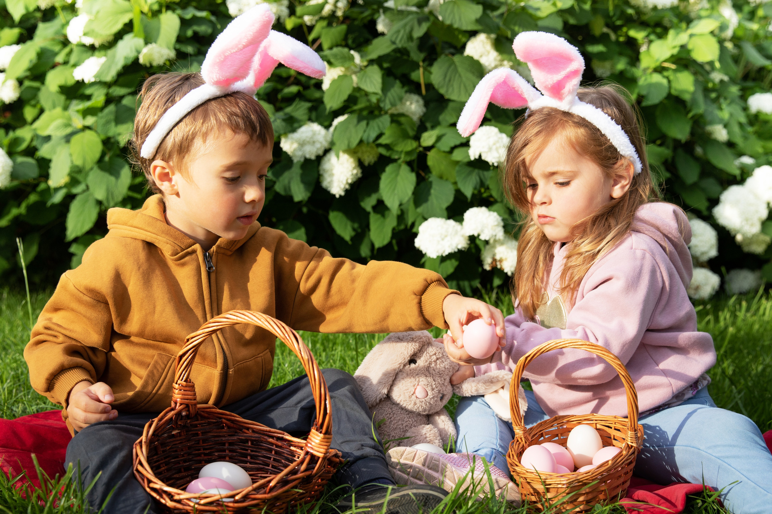Children with bunny ears and coloured eggs. Professional  photographer Oksana Lomnova