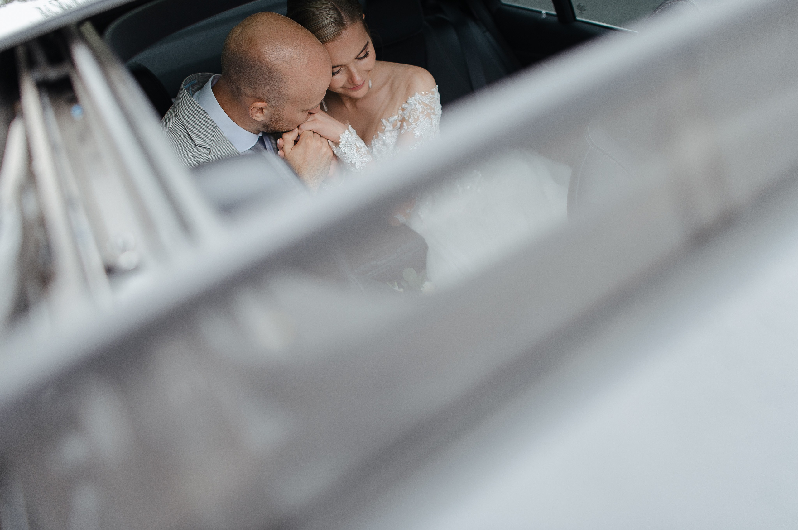 Жених целует руку невесте в ммашине