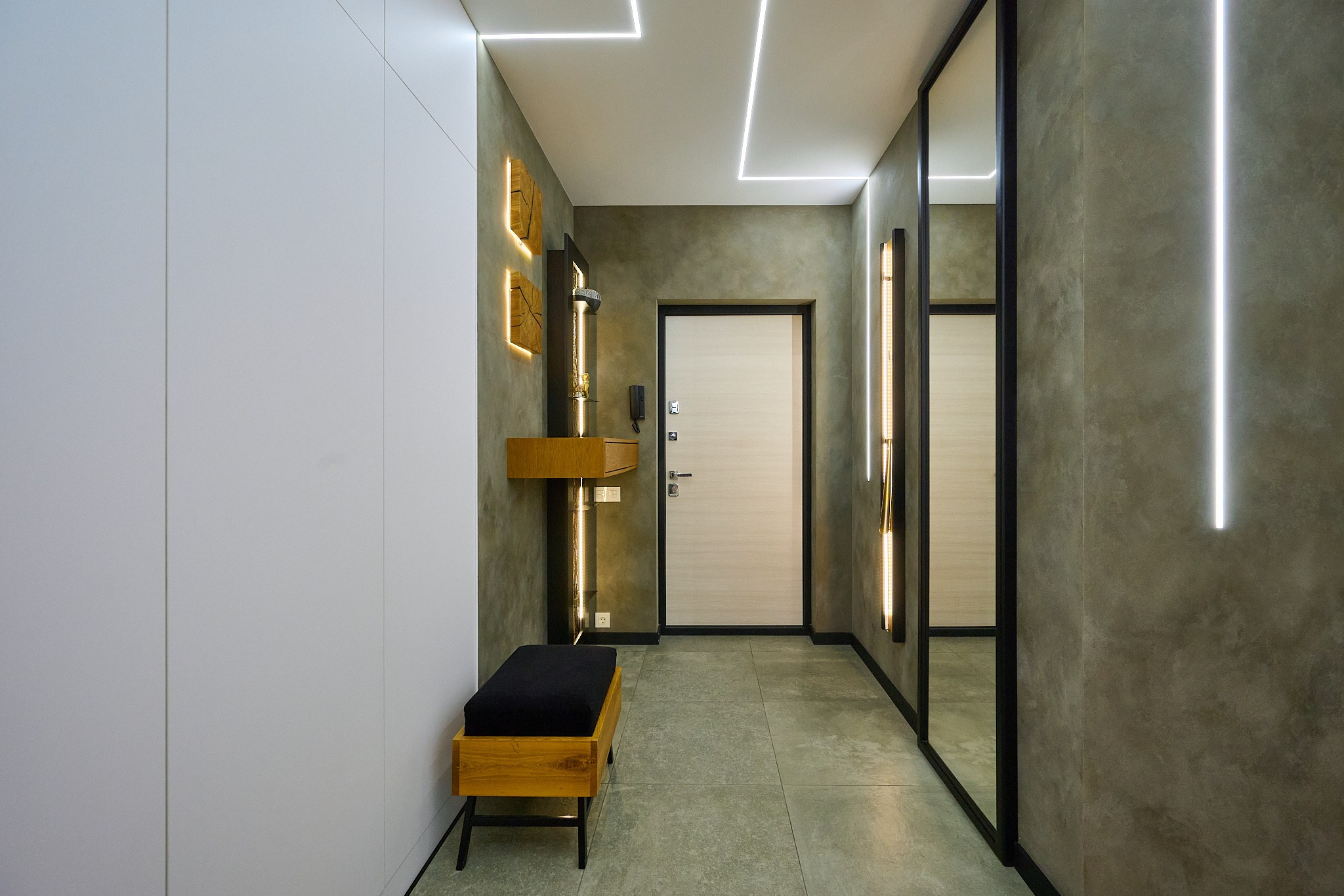 коридор белая входная дверь с серой стенкой и коричневыми полками 