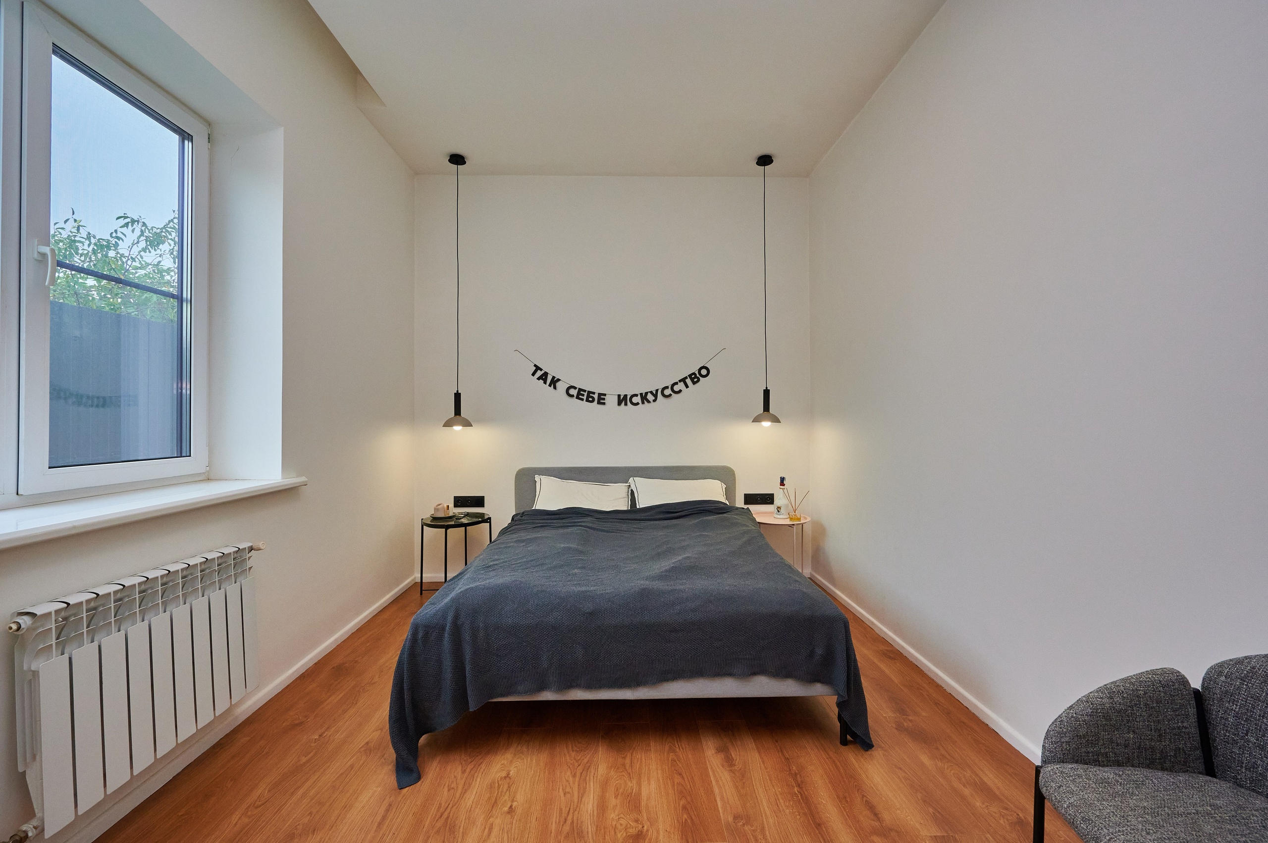 комната светлый ламинат серая кровать  белые стены  серый стульчик