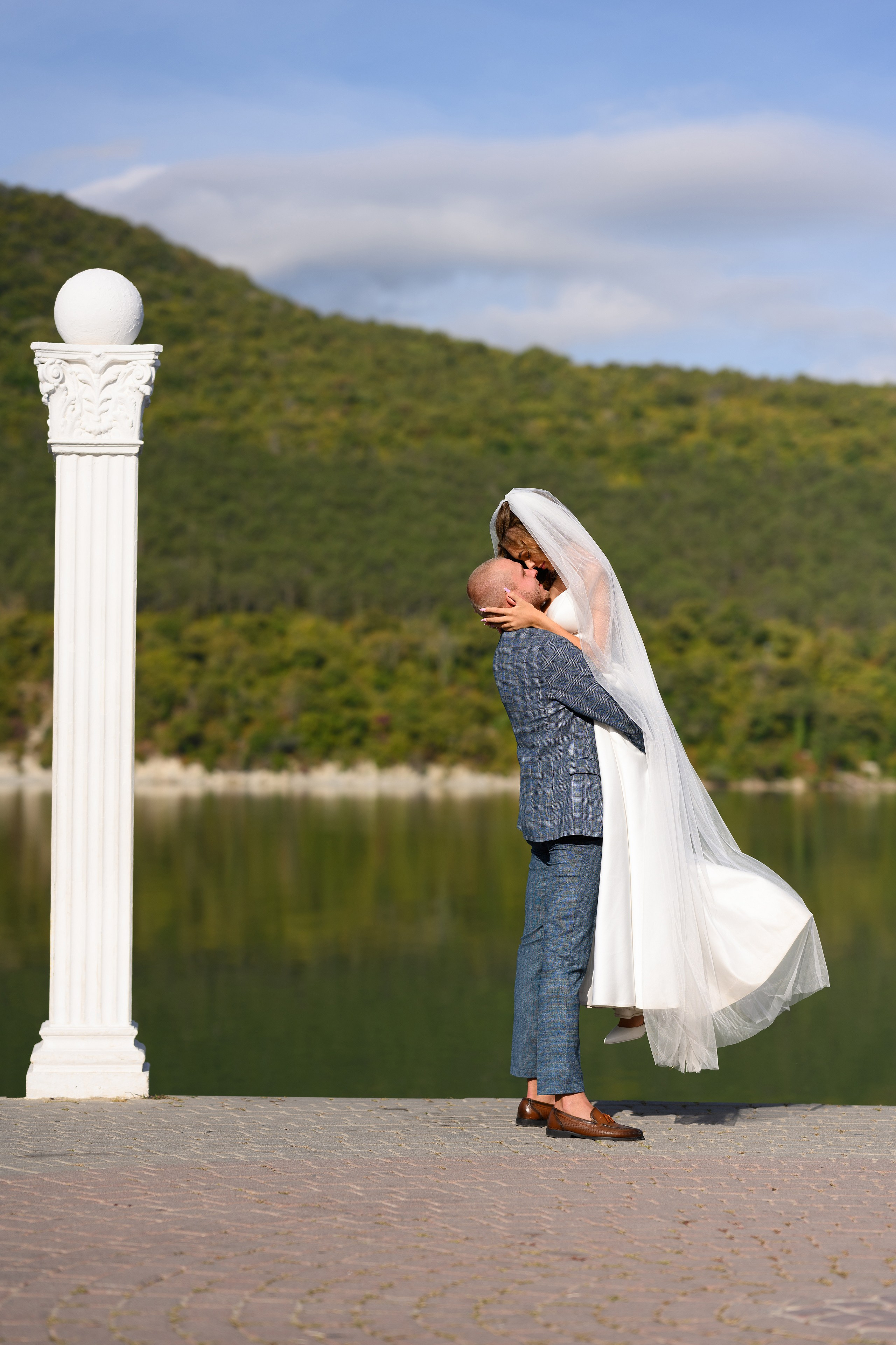 Жених поднимает невесту.