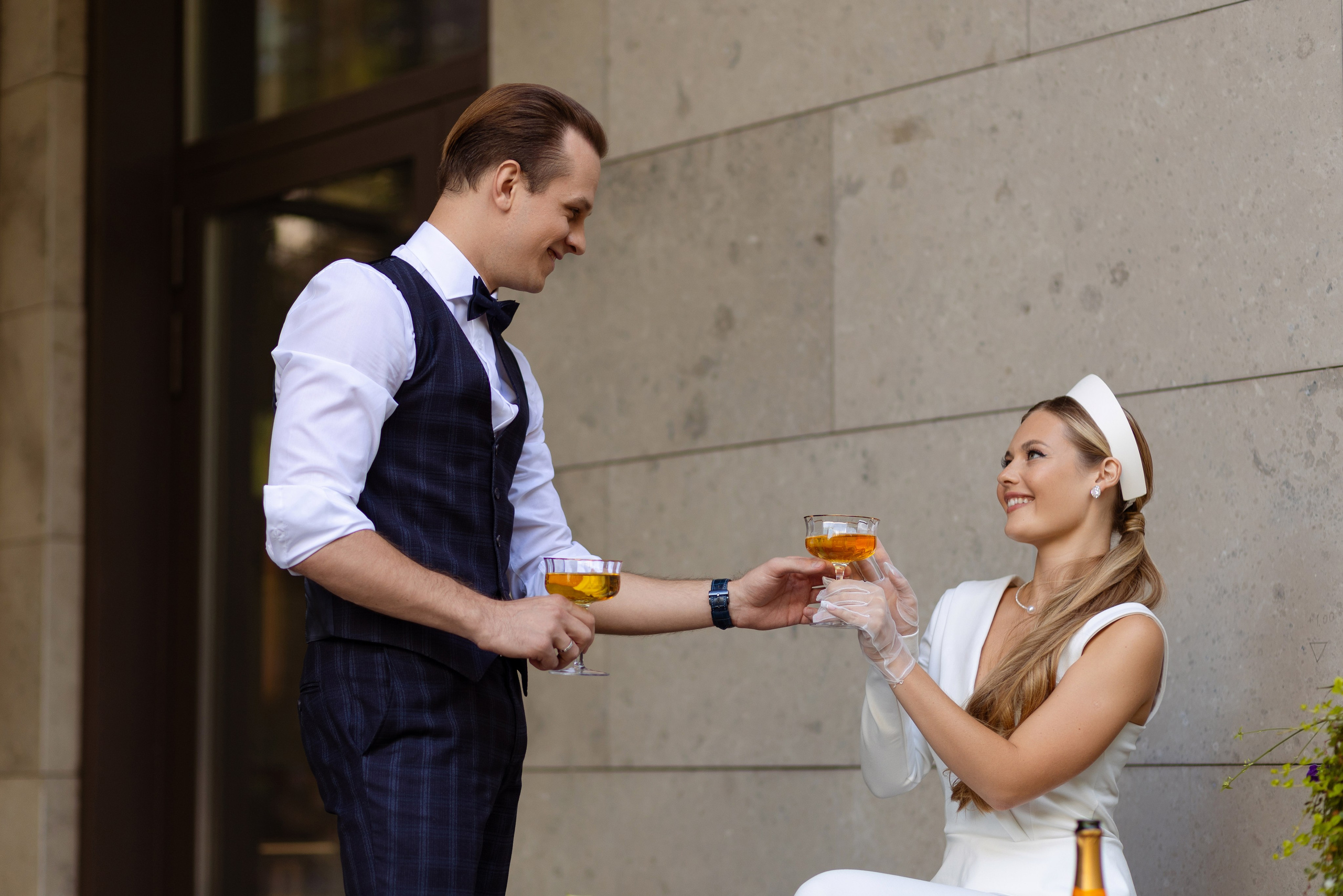 Жених протягивает бокал невесте.