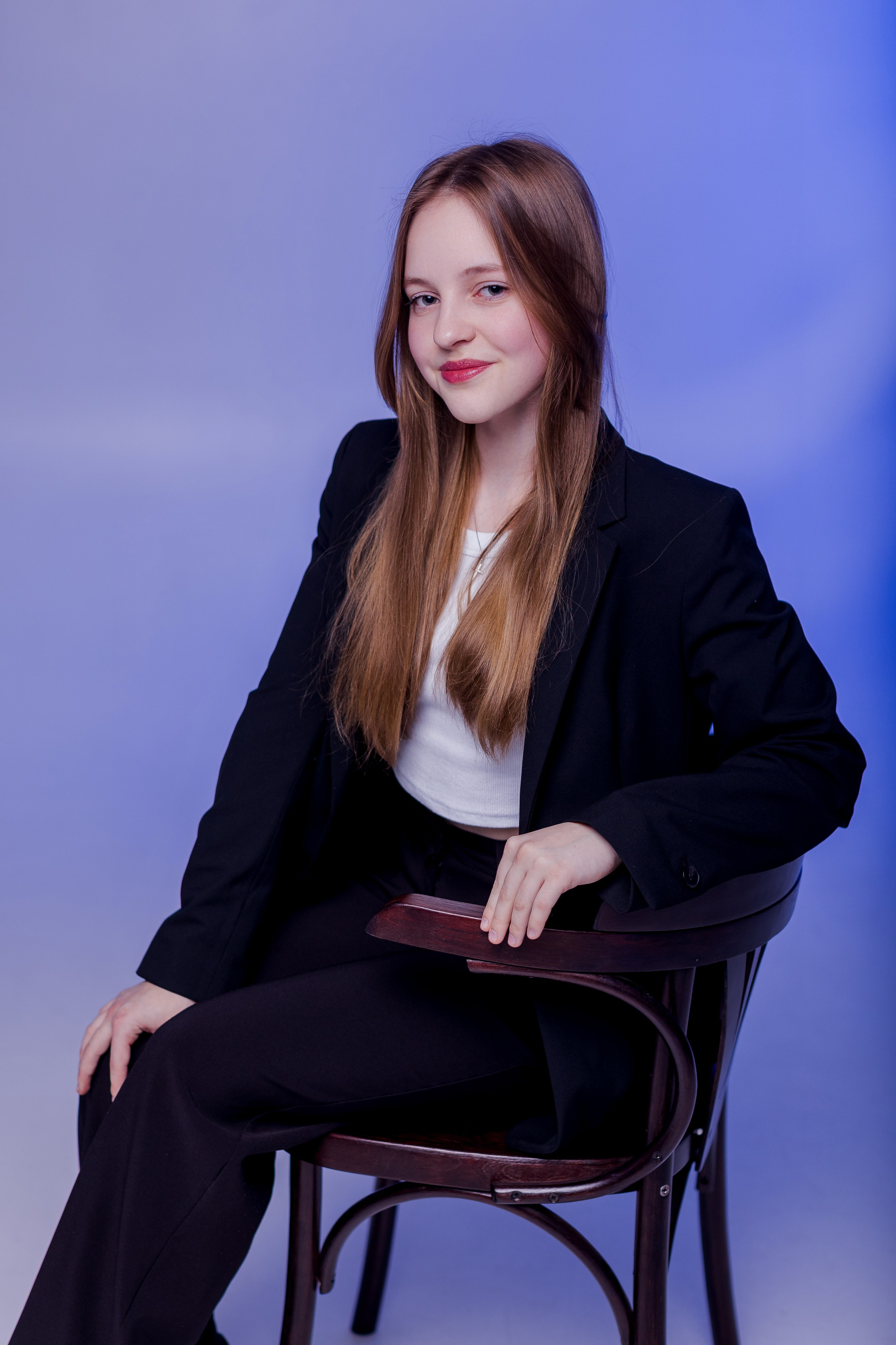 Портрет девушки на стуле в фотостудии с цветным светом