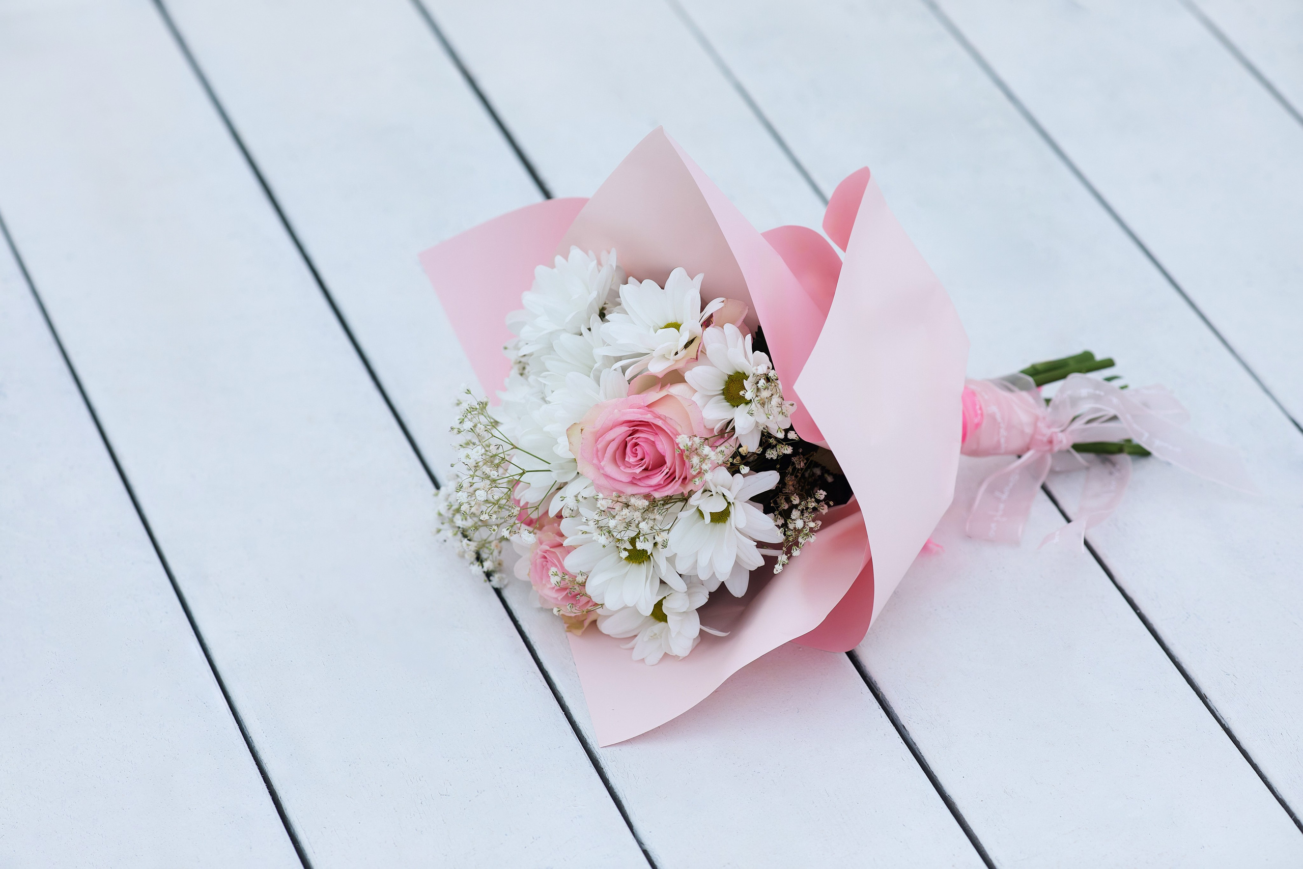 Фото со свадебным букетом на фоне белых деревянных досок