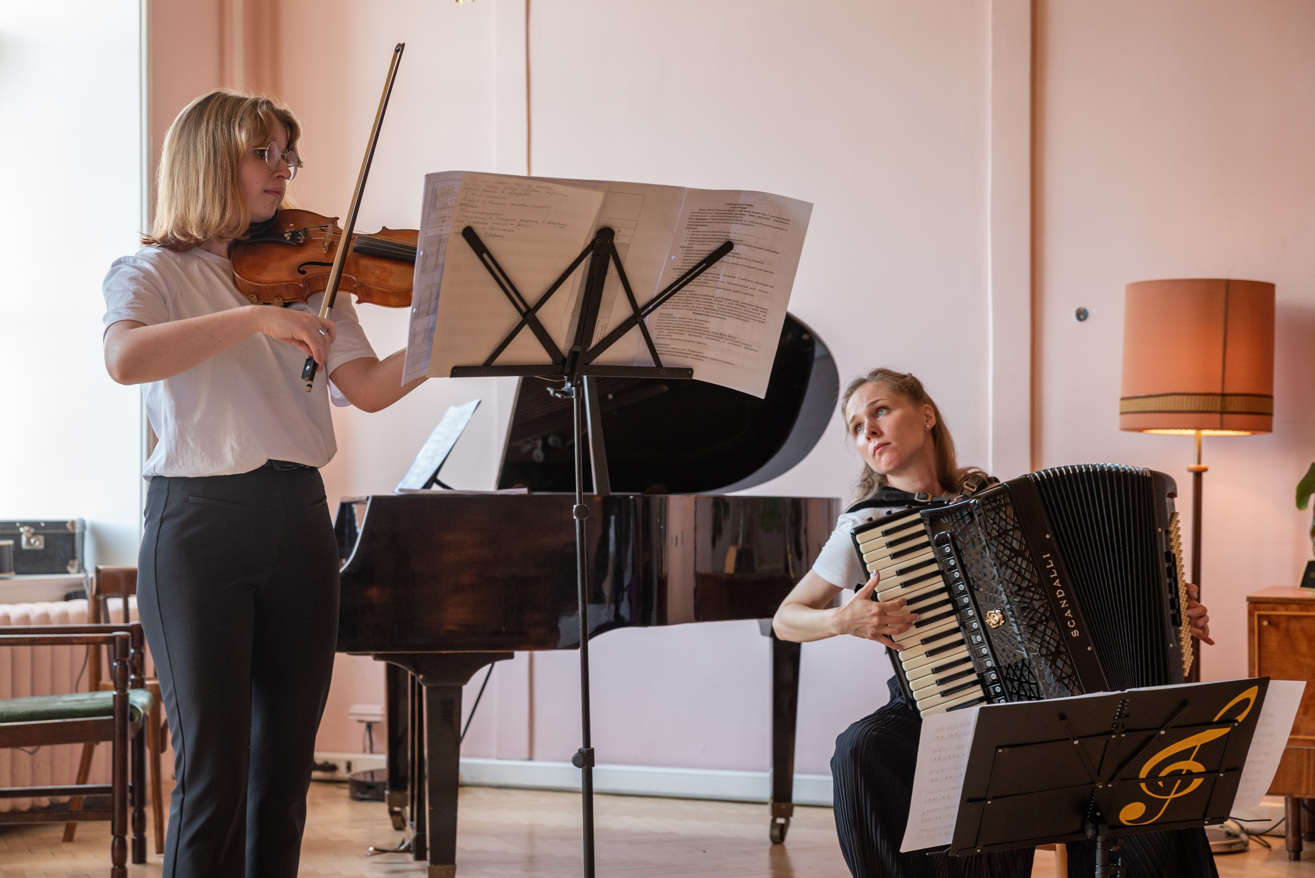 Две девушки играют на аккордеоне и скрипке.