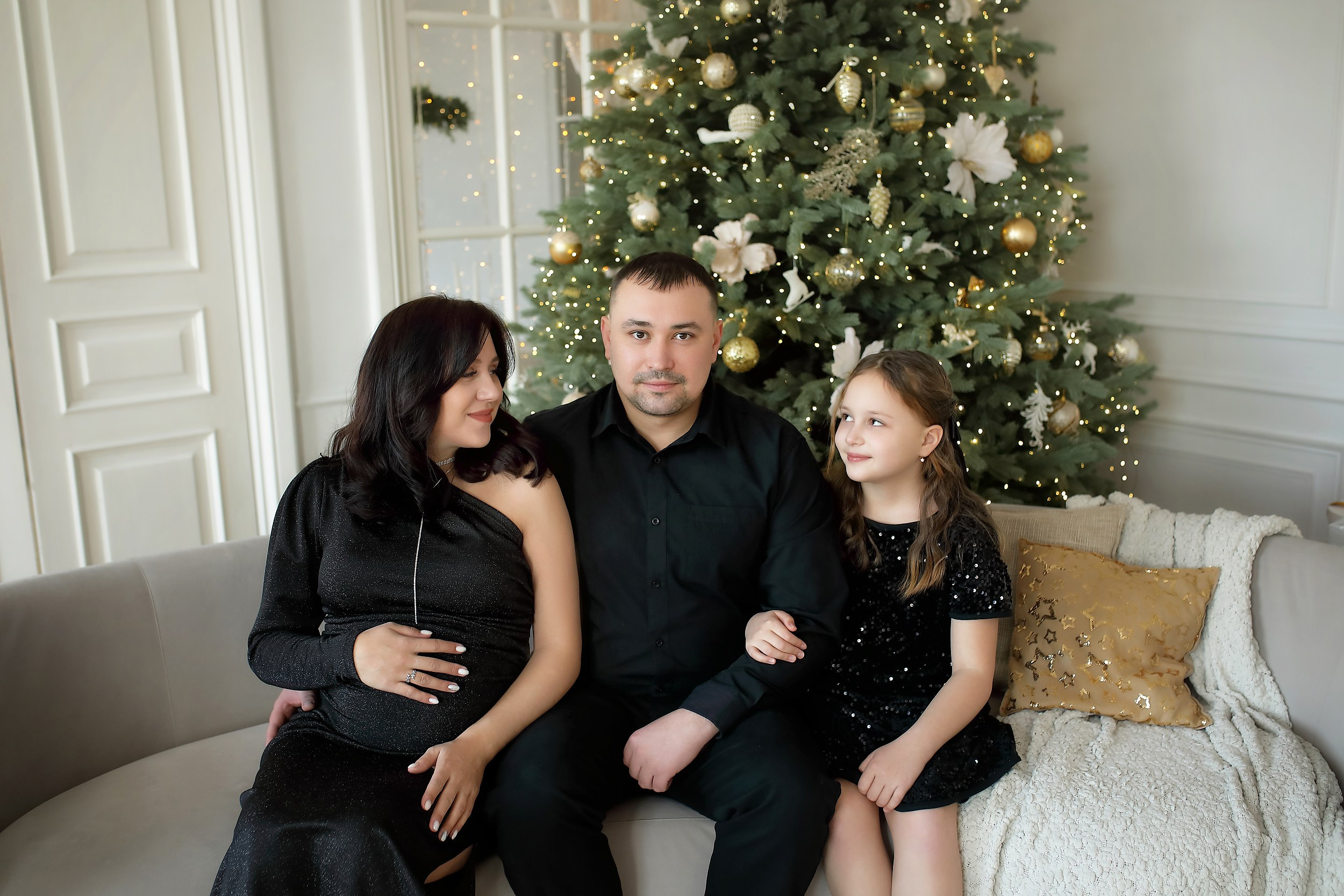 семья на диване на фоне ёлки